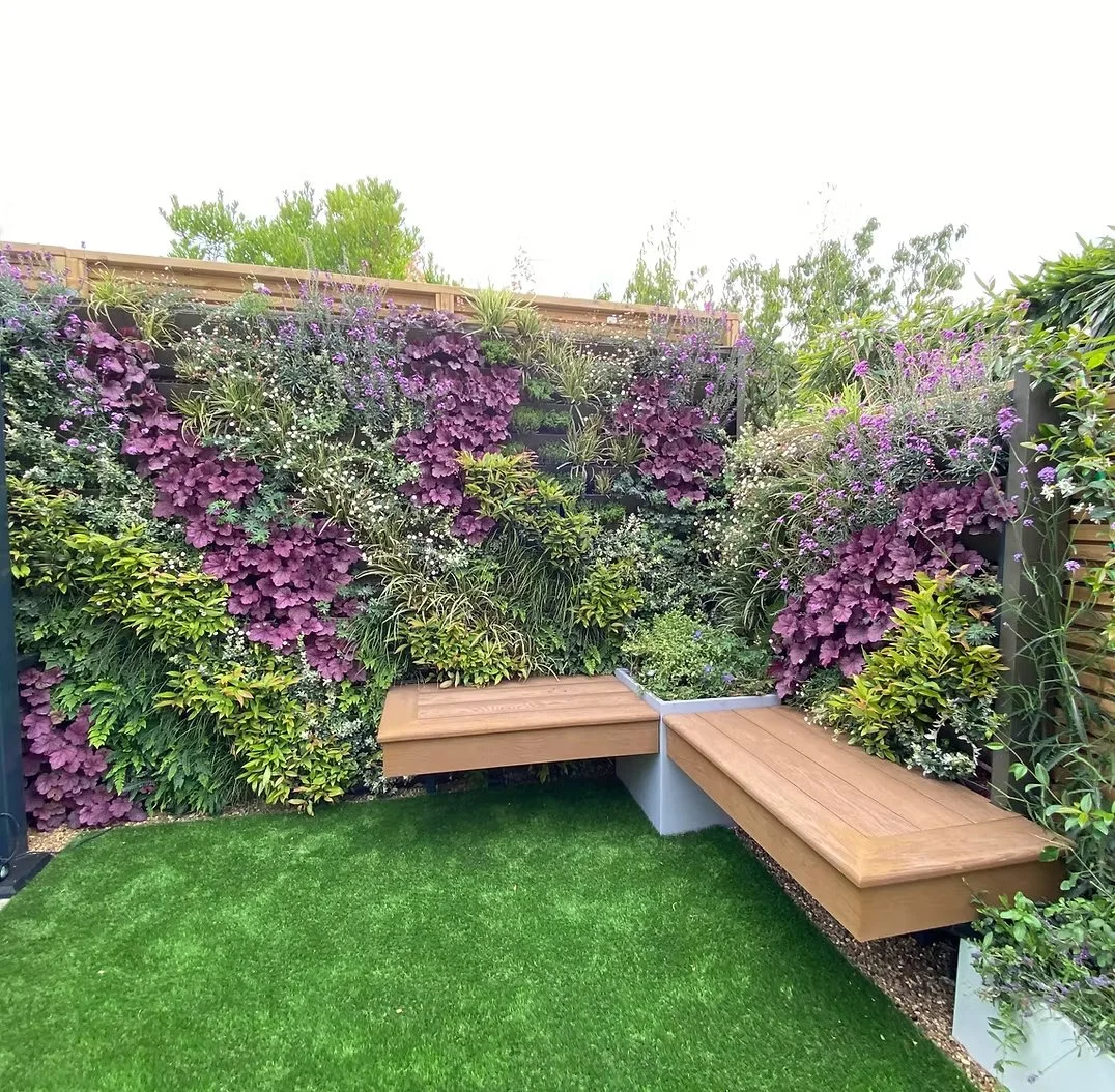 Vibrant living wall with diverse plants in vertical garden design, showcasing lush foliage and colorful flowers