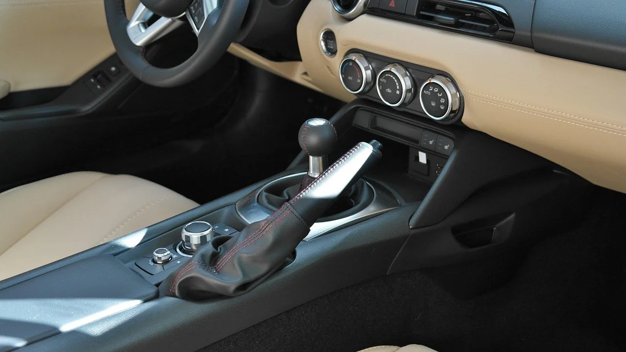 Interieur van een auto, met een versnellingspook, stuurtje, en klimaatregeling op het dashboard