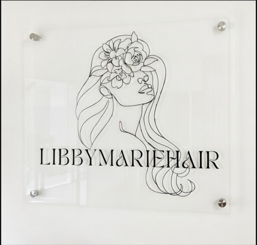 Line art drawing of a woman with flowing hair and flowers in her hair, with the text 'LibbyMarieHair' below.