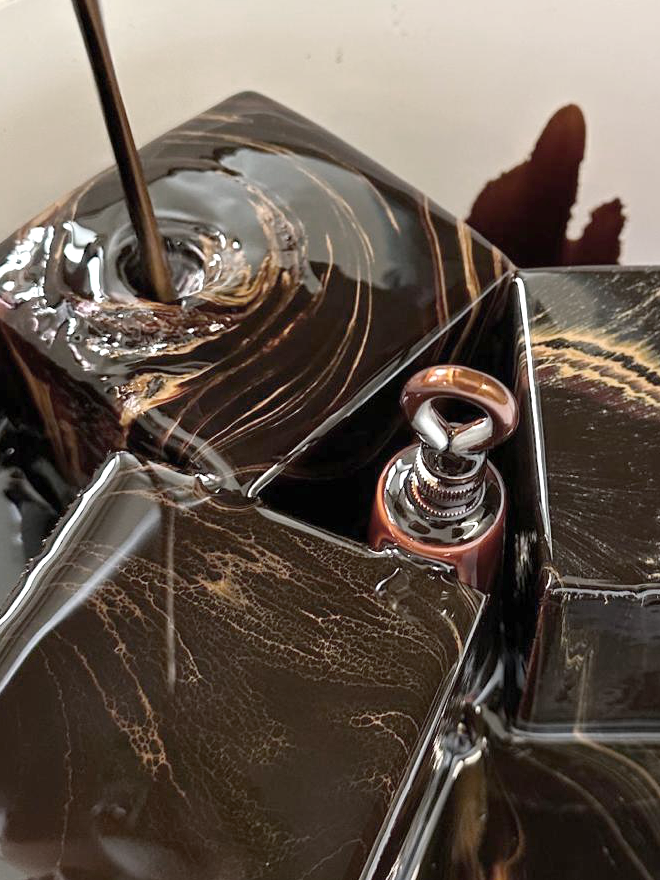 Close-up of the hyperlignification process showing the glossy surface of the lignin liquid being poured over wood.