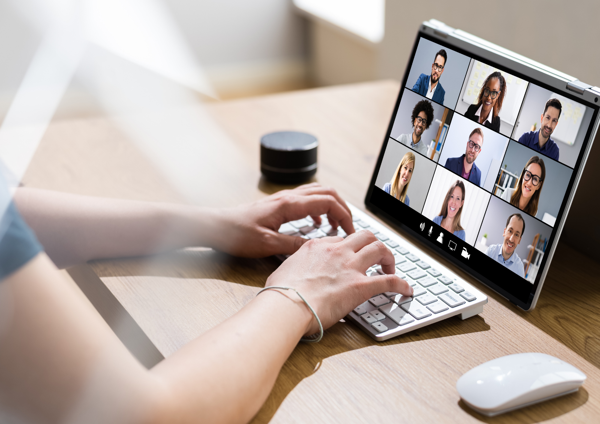 Person participating in a virtual meeting on a tablet with multiple diverse colleagues visible on screen.