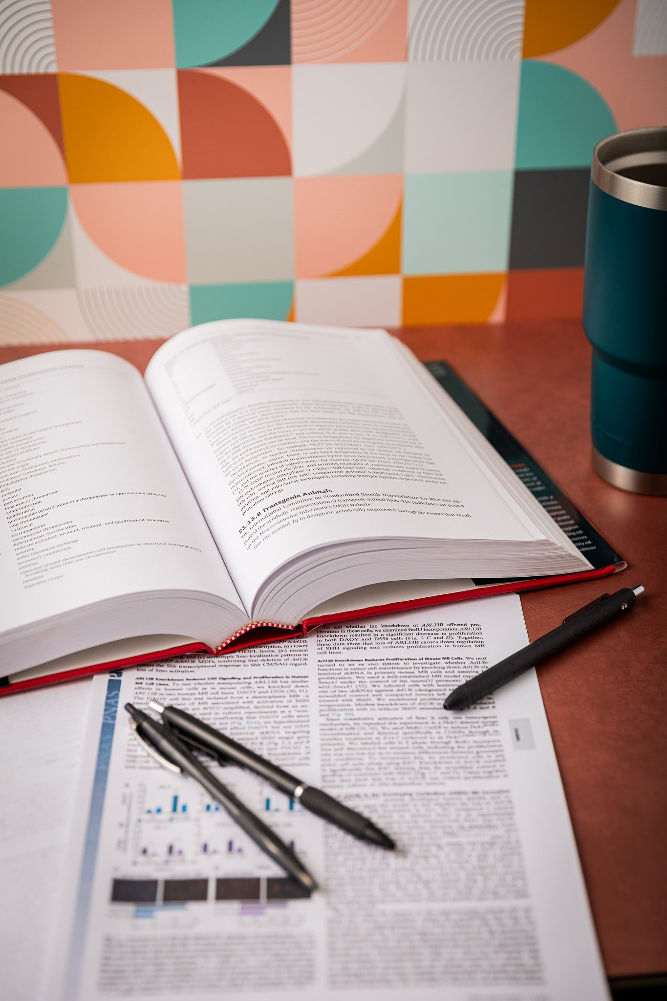 An academic manuscript in the life sciences on a table with pens and the Scientific Style and Format manual open,