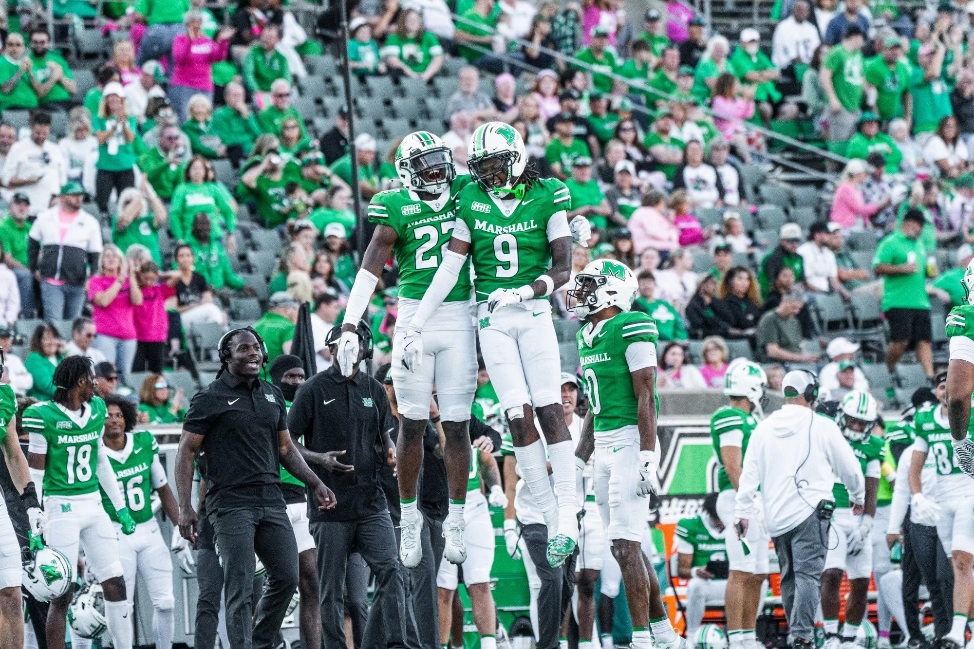 Southern Miss football players celebrating on the field with fans in the stands.
