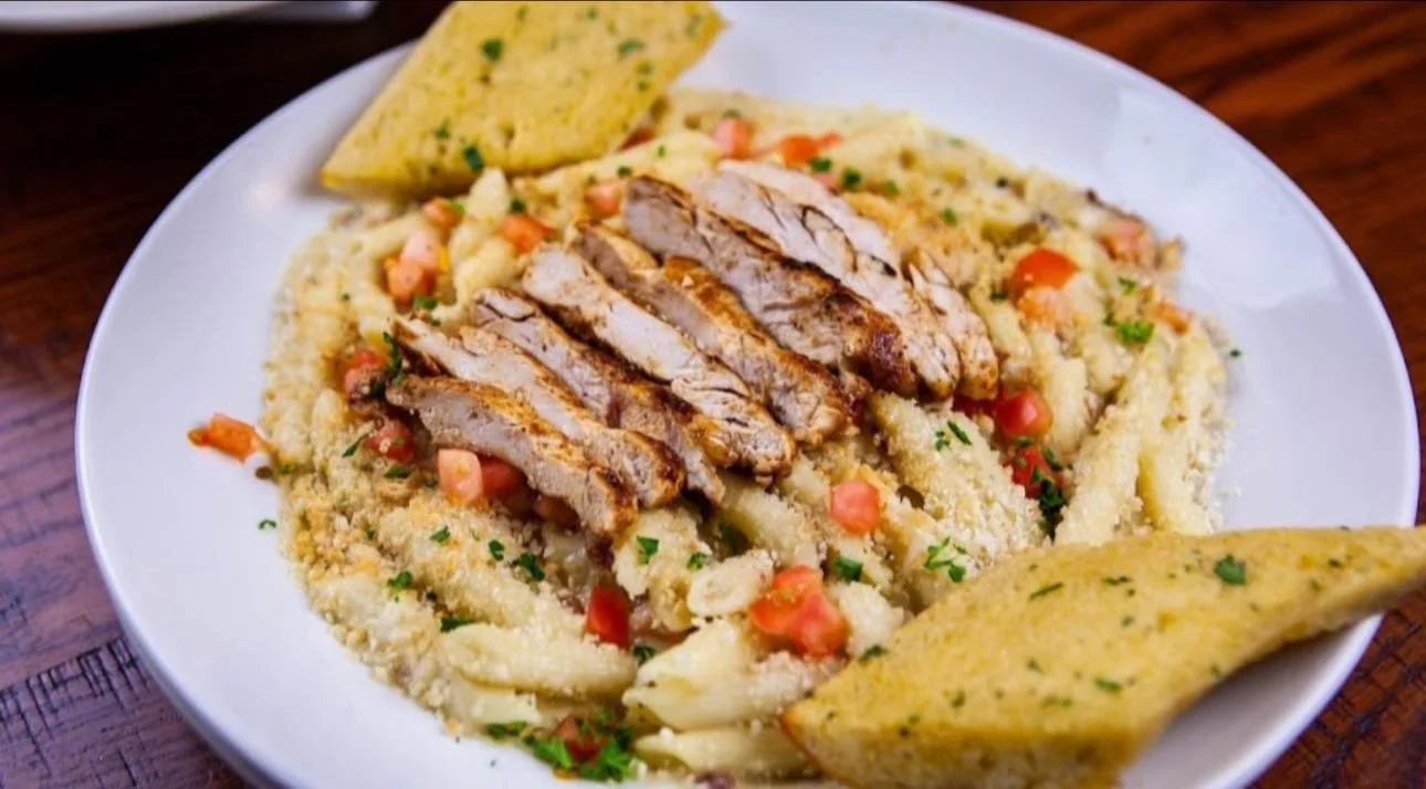 A plate of Mexican food with grilled chicken slices, rice, pico de gallo, and tortilla chips.