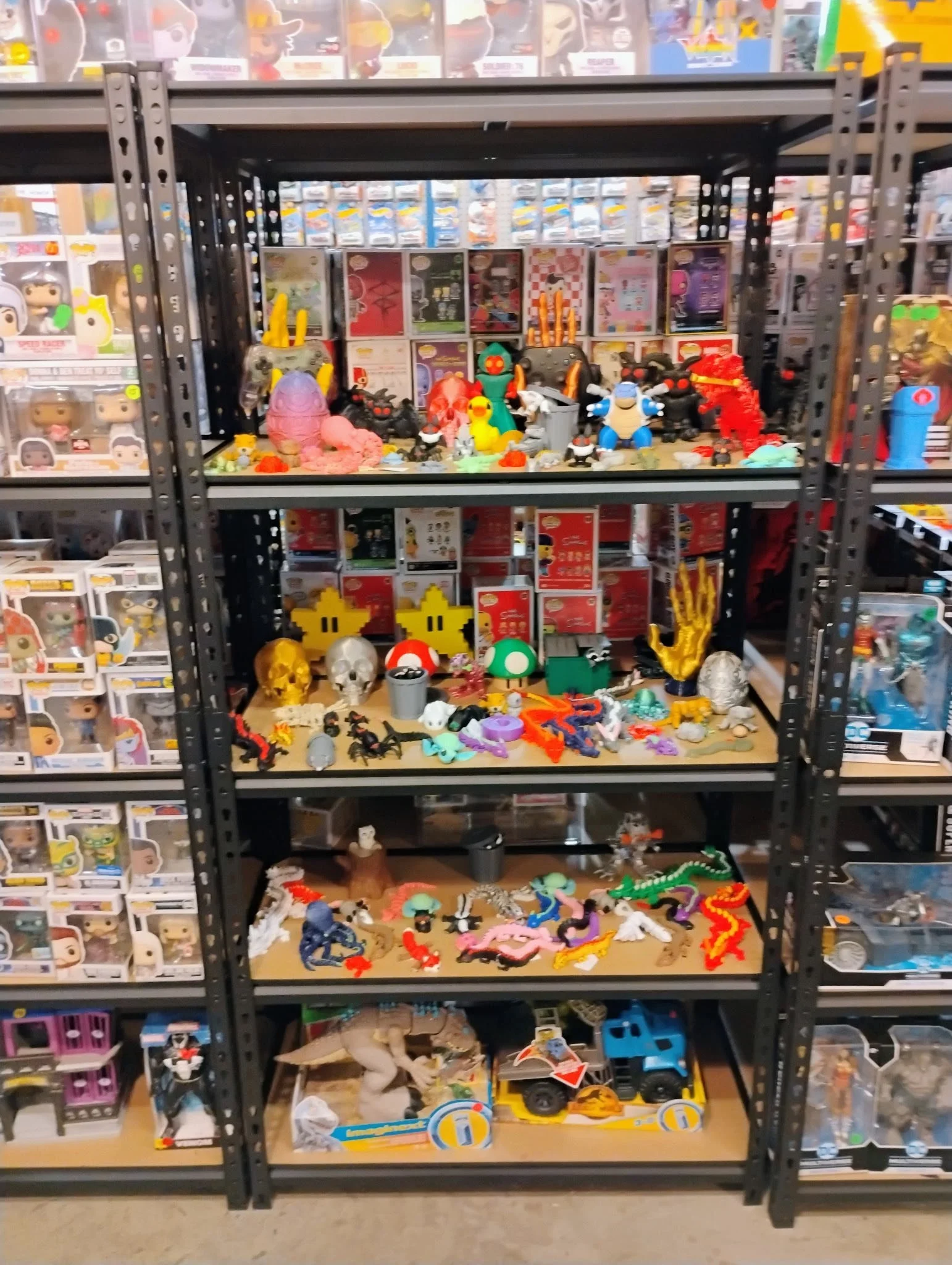 Shelves filled with various collectible toys, including Funko Pop figures, mystery mini figures, and colorful plastic creatures, set in a toy store.