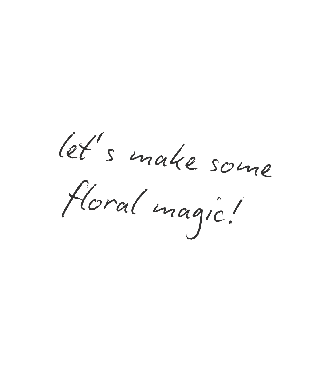 Close-up of a black surface with handwritten text that reads, "let's make some floral magic!"