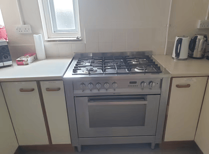 Kitchen with a gas stove, countertop, and appliances including a kettle and toaster.