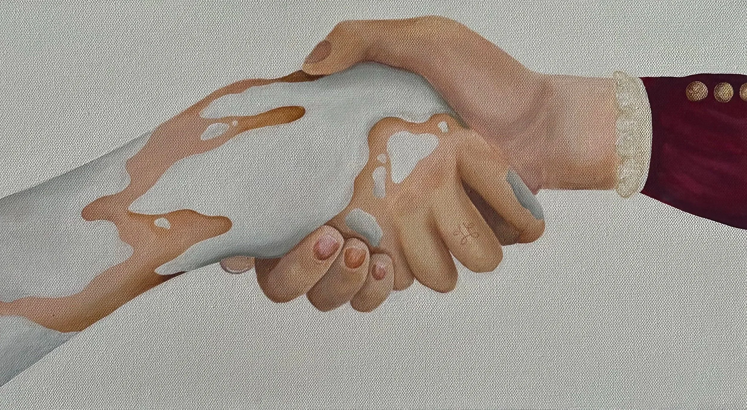 Close-up of two hands engaged in a handshake, with one hand appearing more feminine and the other more masculine. The feminine hand is dressed in a maroon sleeve with gold buttons, while the masculine hand is plain. A liquid, possibly coffee or tea, 