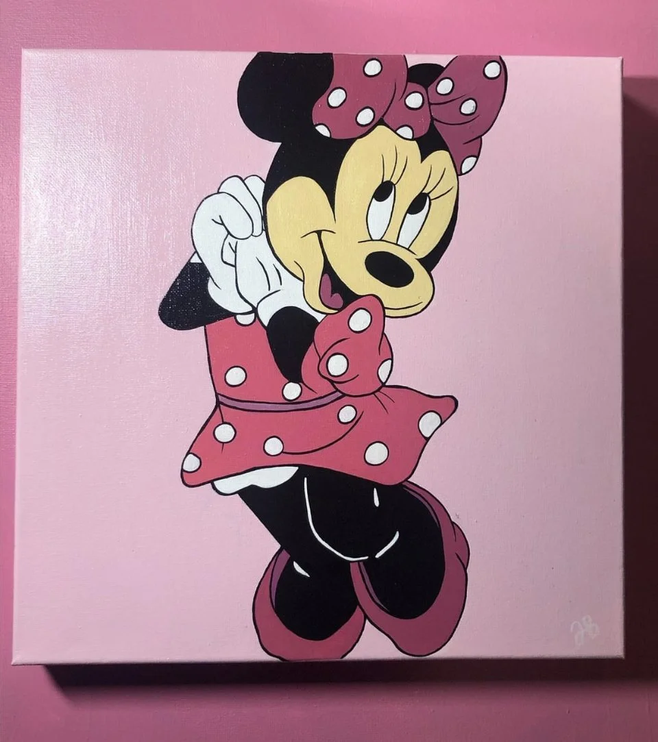 Painting of Minnie Mouse on a pink canvas with a pink background, showing her winking and smiling, wearing a polka dot pink bow and dress.