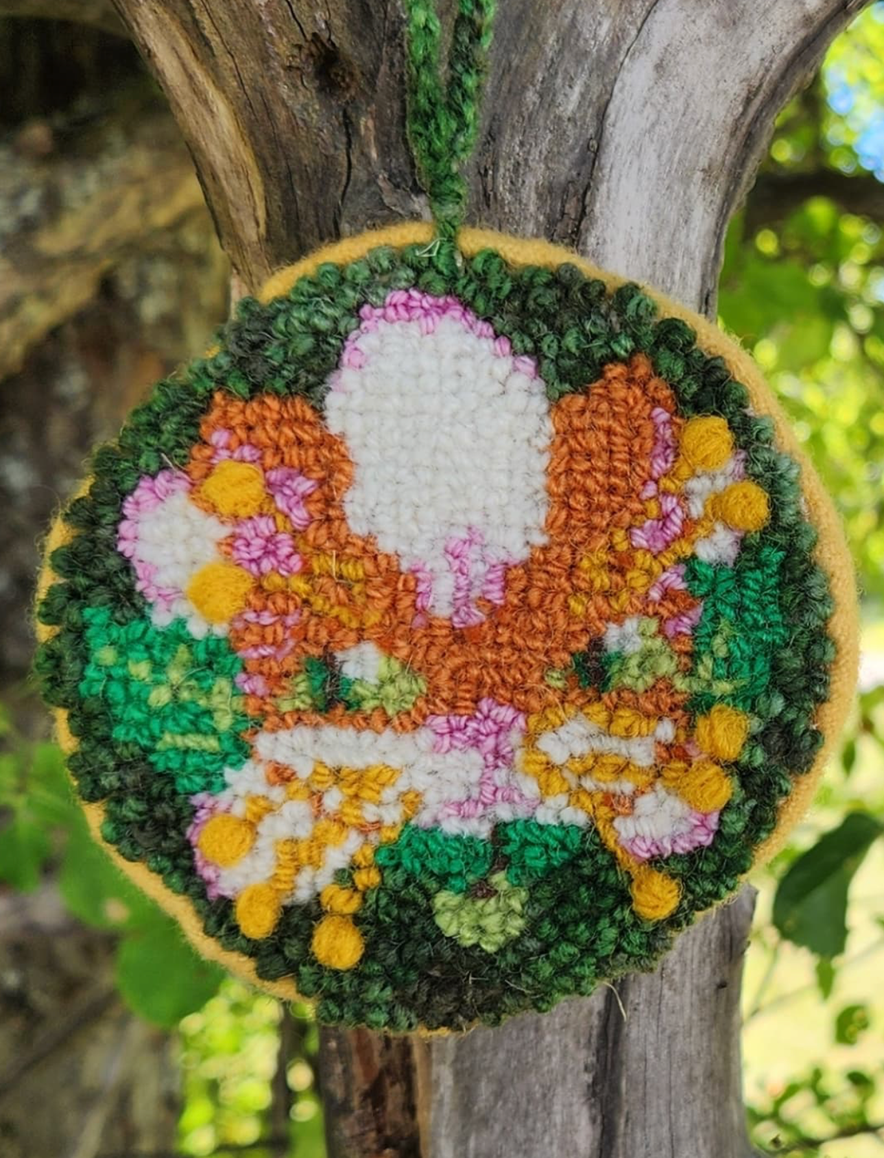 Colorful yarn butterfly decoration hanging from tree branch
