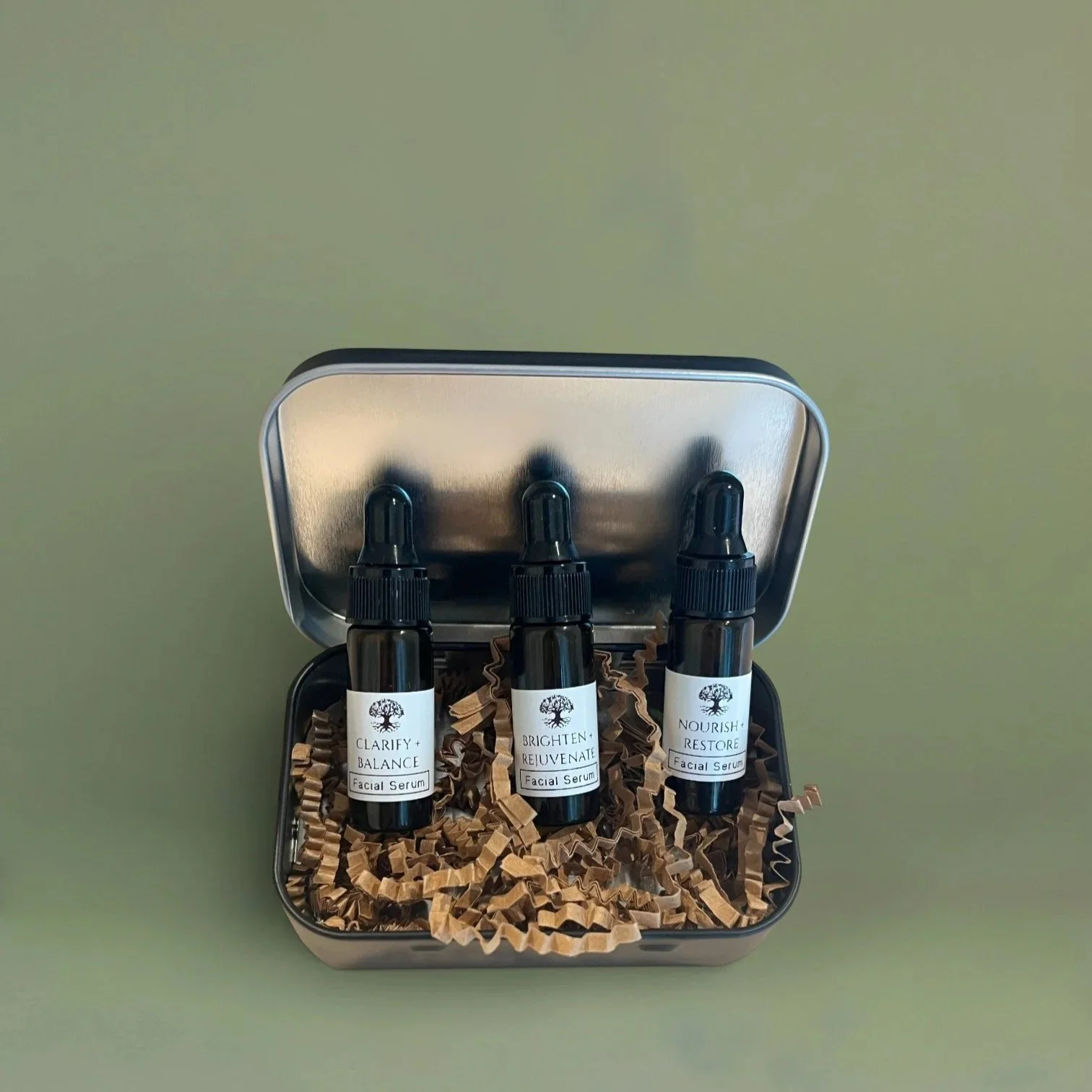 open metal tin with 3 vials of travel size facial oils for congestion prone, dull, and mature aging skin