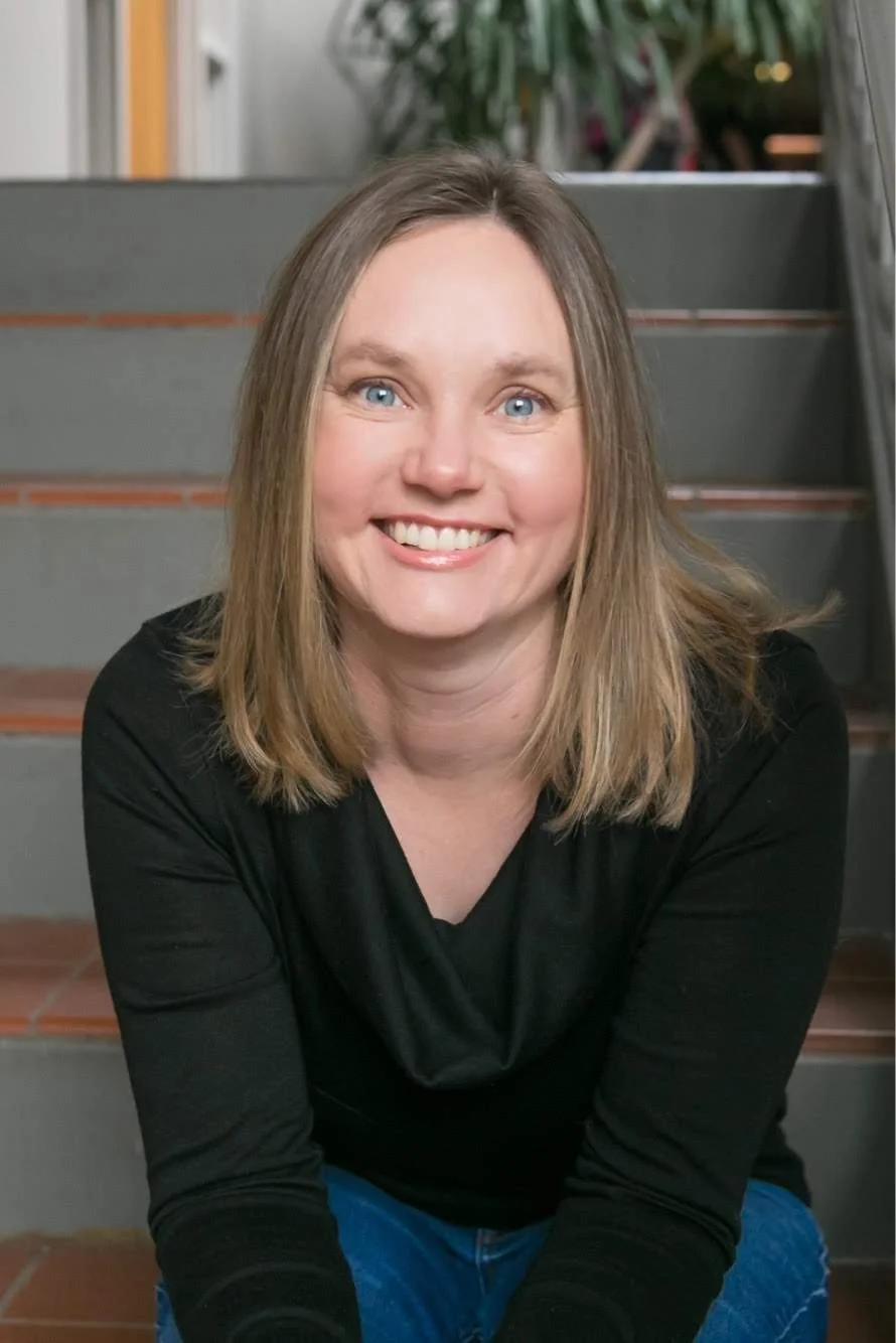 Dr. Irene Kraegel, PsyD sitting outside her therapy office with shoulder-length blonde hair, blue eyes, wearing a professional black top.