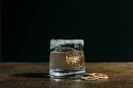 Glass of water with a lemon slice on a wooden surface