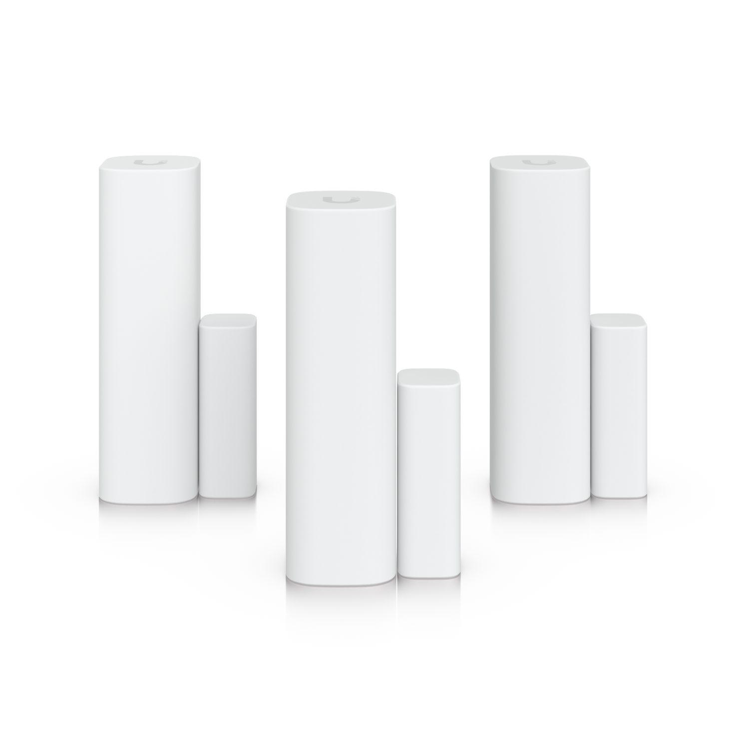 Three white cylindrical objects on a reflective black surface with a black background. Additional cylindrical objects are visible at the sides.