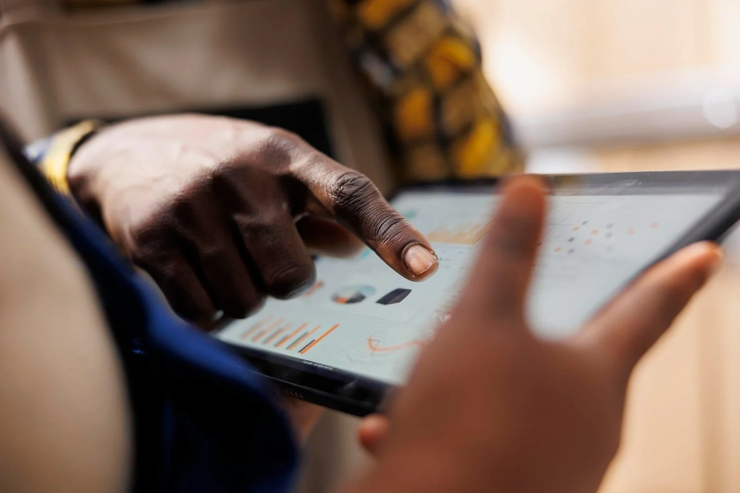 Une personne utilisant une tablette tactile, appuyant avec son doigt sur l'écran.
