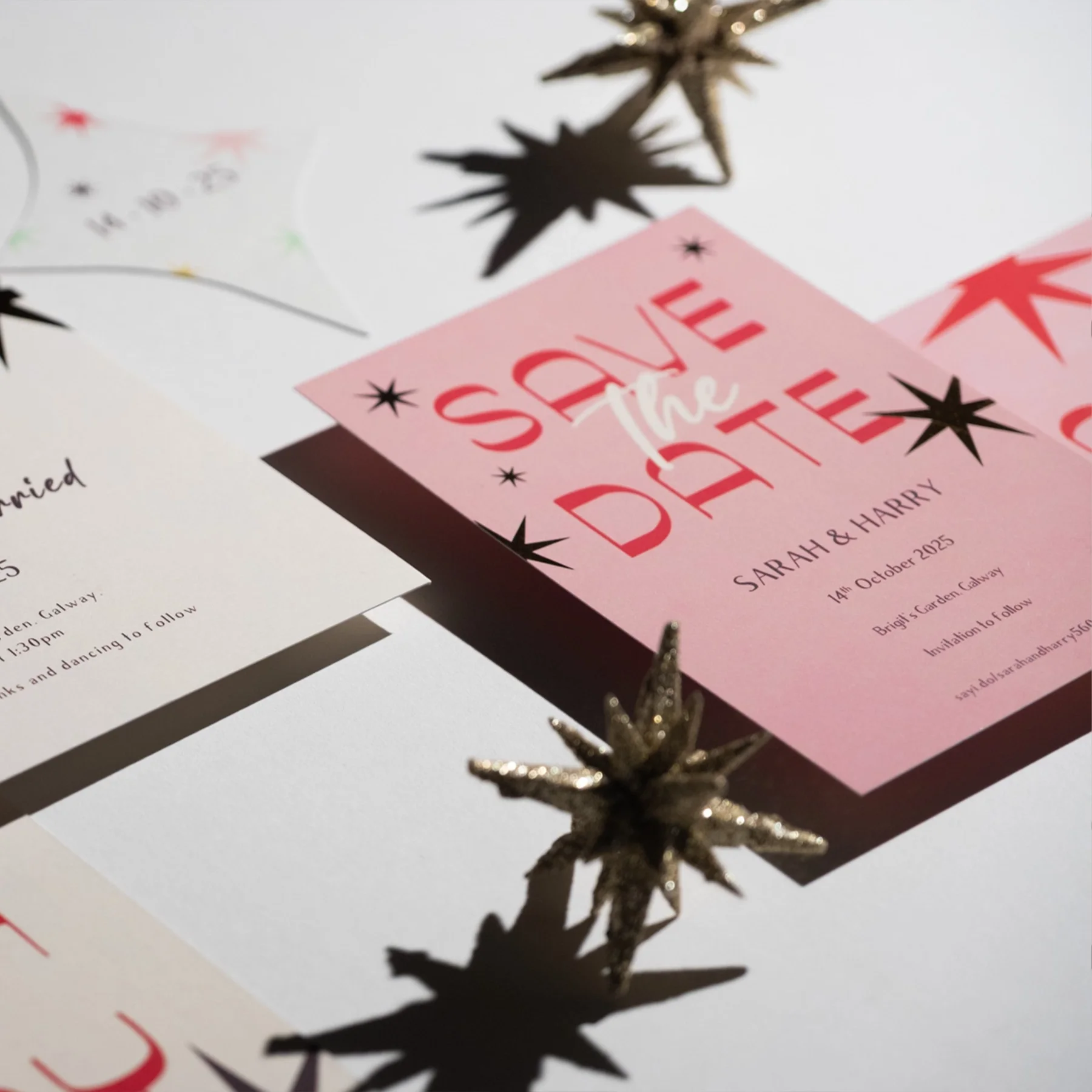 Wedding invitation with pink and white paper, decorated with gold star-shaped ornaments and black star illustrations.