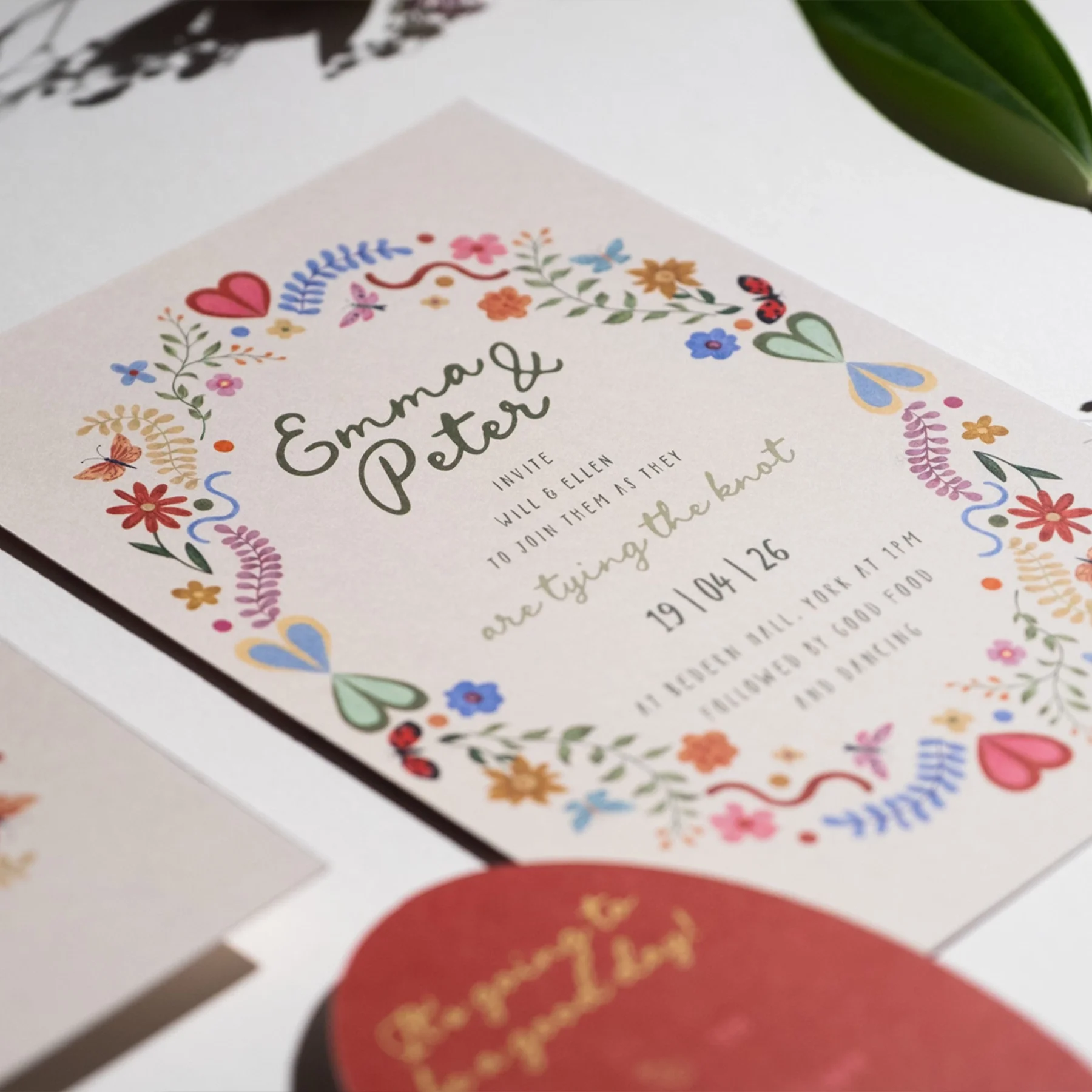 A wedding invitation with colorful floral and heart illustrations, featuring names Emma and Peter, and details about the event on October 26 at 11 PM in New York.