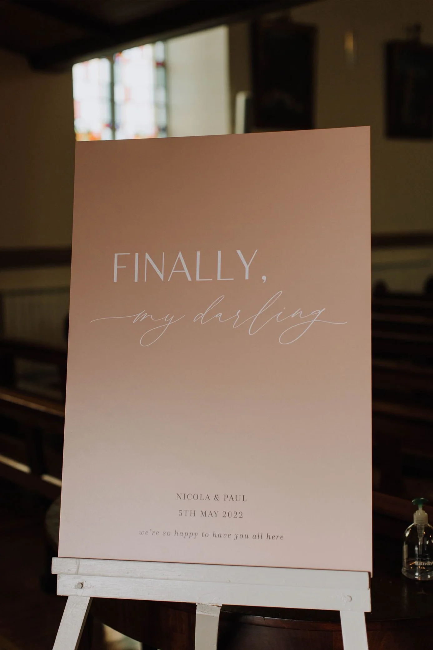 A wedding or celebration sign with the message 'Finally, my darling' and details for Nicola and Paul on May 5th, 2022, on a small easel.