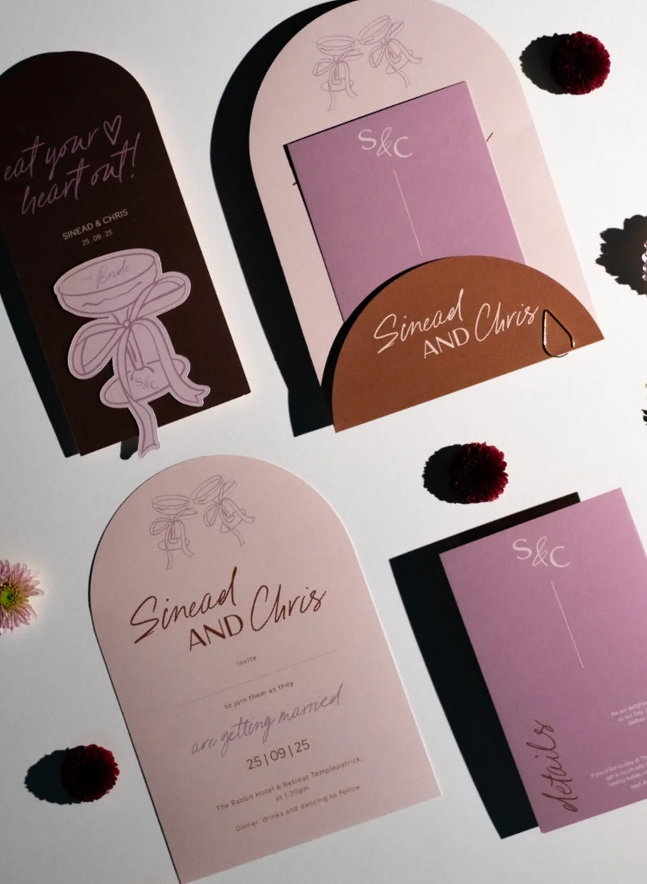 Wedding invitation cards and stationery for Sinaed and Chris, with pink and brown color schemes, featuring floral and bow illustrations, and small decorative pom-pom embellishments.