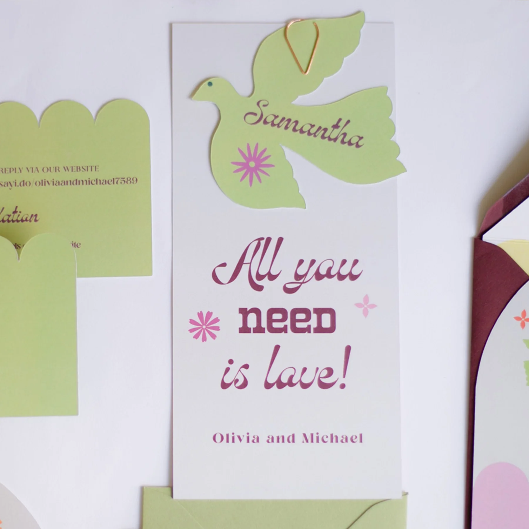 A decorative card with the word "Samantha" inside a green dove shape with pink accents, alongside the phrase "All you need is love!" and the names "Olivia and Michael."