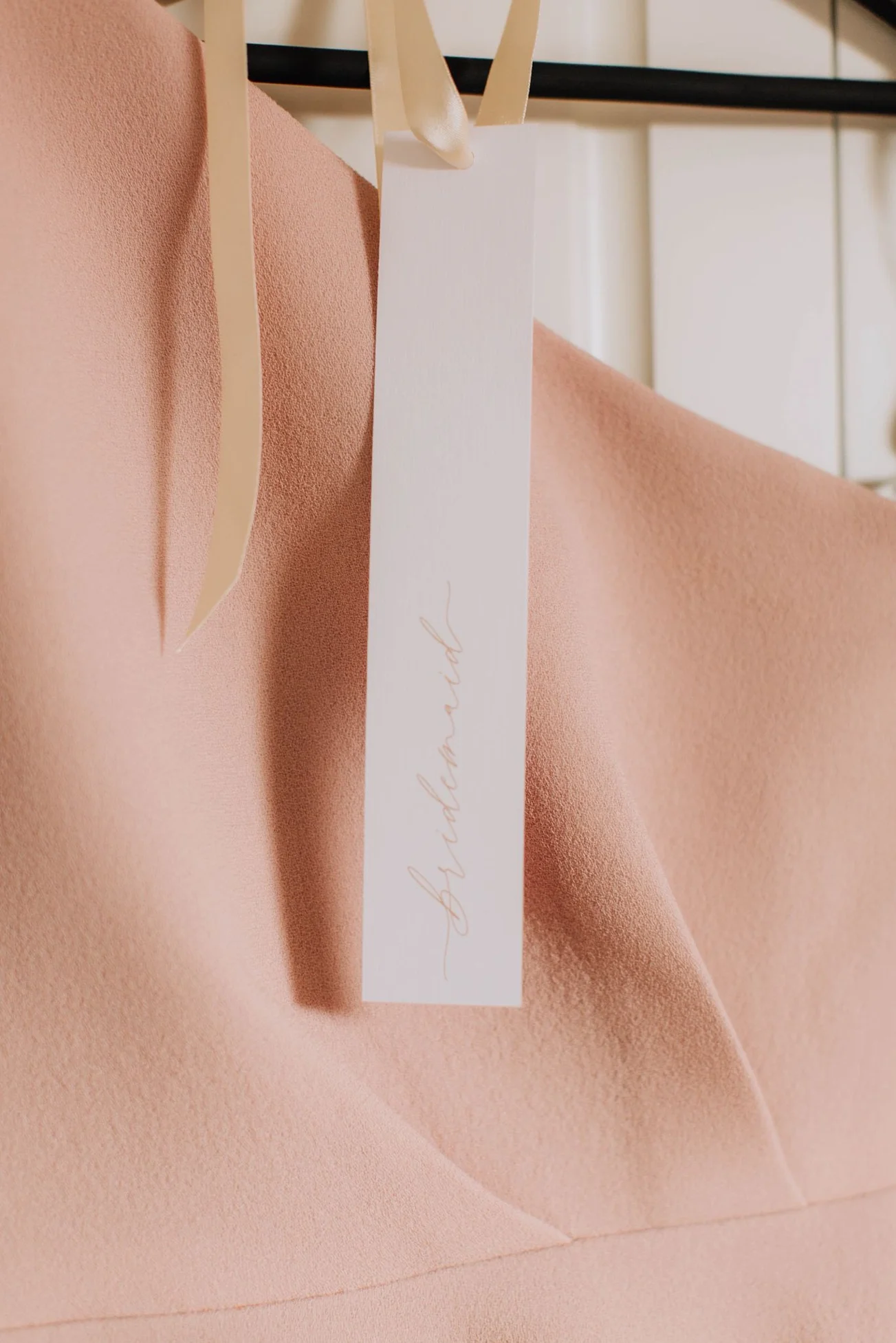 A light pink fabric with a white tag hanging from it, with the word 'stylearn' written in cursive.