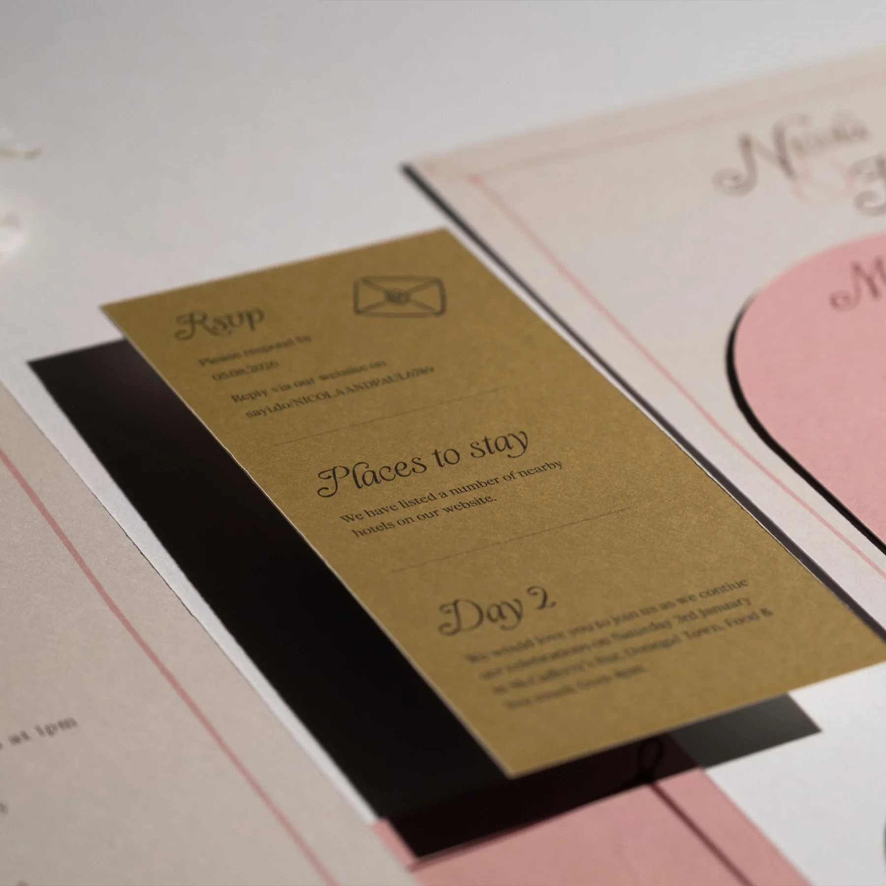 A set of wedding or event informational cards, including a gold card listing hotels and nearby places to stay, and another pink card with decorative text.