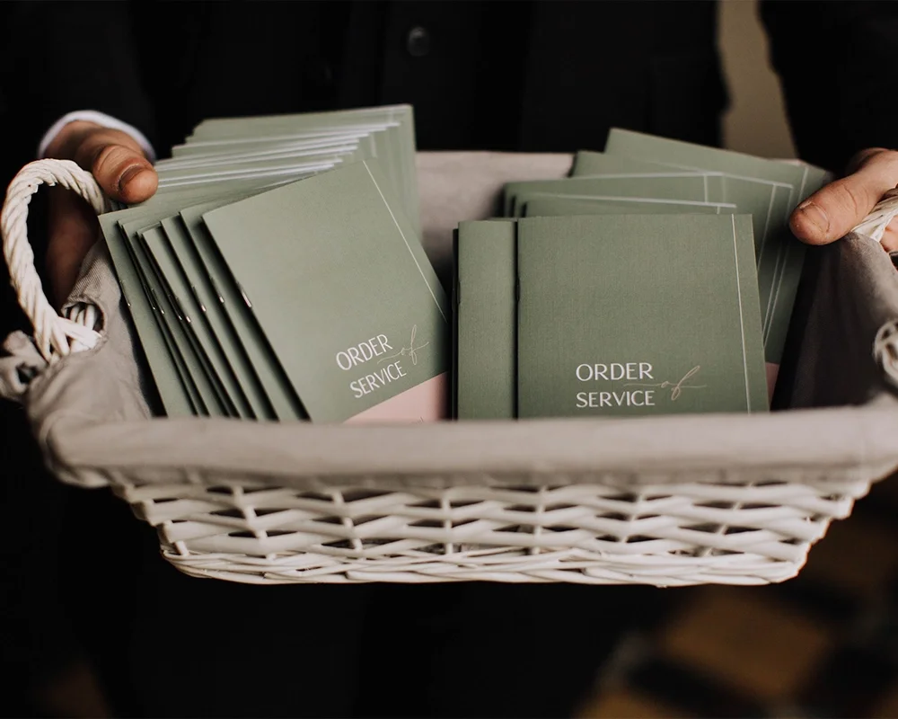 Person holding a basket filled with green cards labeled 'Order & Service'.