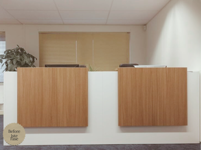 Strakke, moderne receptiebalie met eikenhouten fronten en wit paneel in een lichte kantoorentree. Tijdloos interieurdetail dat rust, professionaliteit en een warme ontvangst uitstraalt.