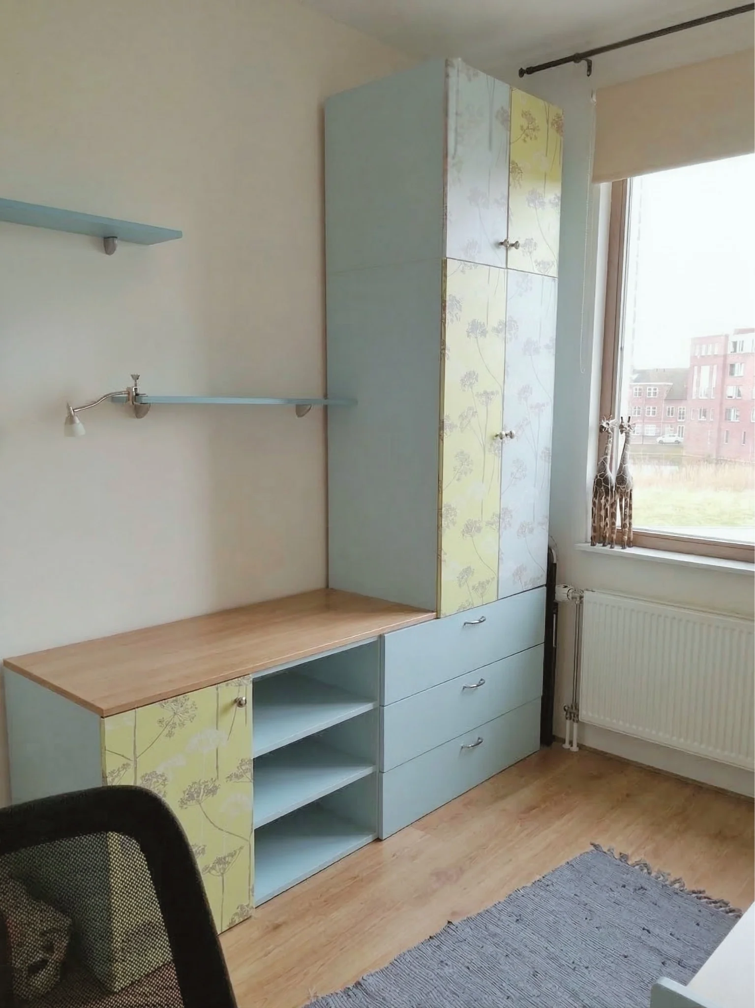 Before: bestaande situatie van de kinderkamer met opbergkast en open vakken bij het raam. Functioneel, maar visueel onrustig. En-Casa vertaalde dit later naar een rustig en volwassen totaalbeeld.