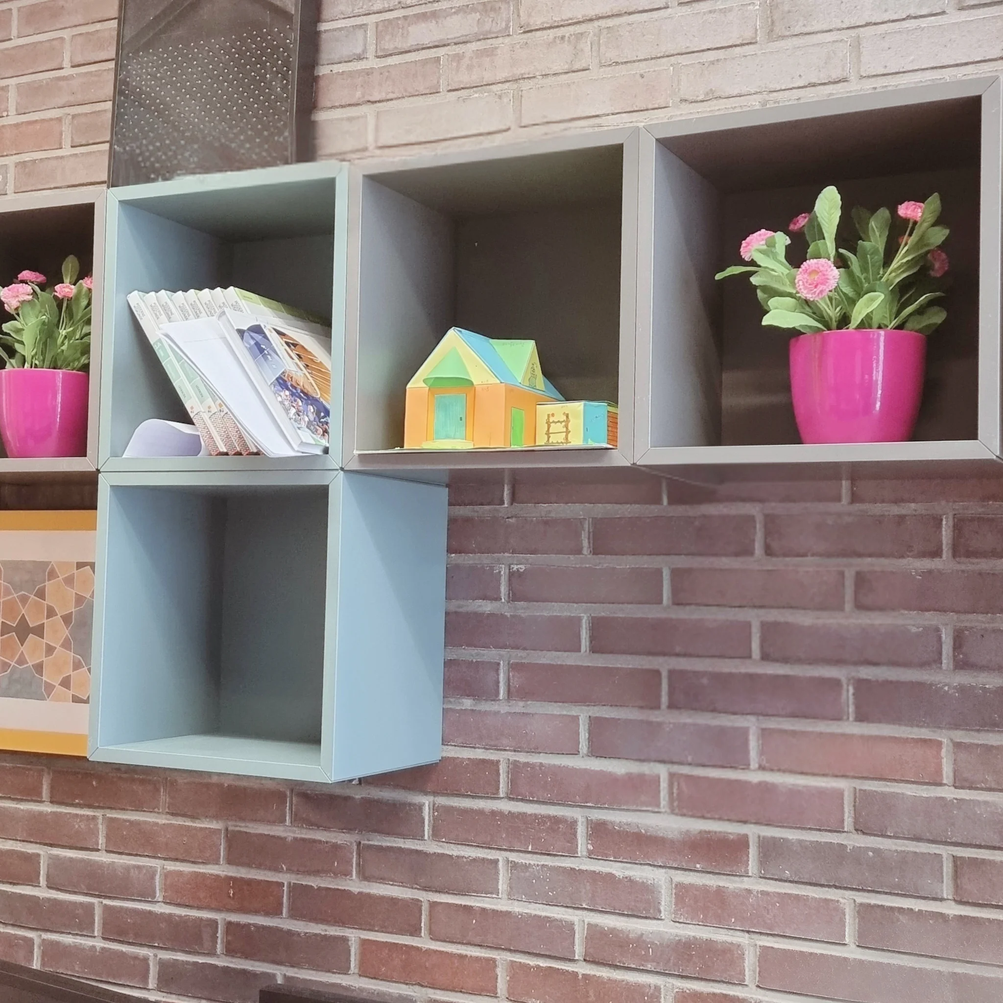 Industriële  docenten studie kamer inrichting met kubus wandkasten als extra opbergruimte, strak maatwerk tegen een bakstenen muur en speelse accenten voor een georganiseerde, warme werkplek. Interieuradvies, ontwerp en styling door En-Casa Interiors