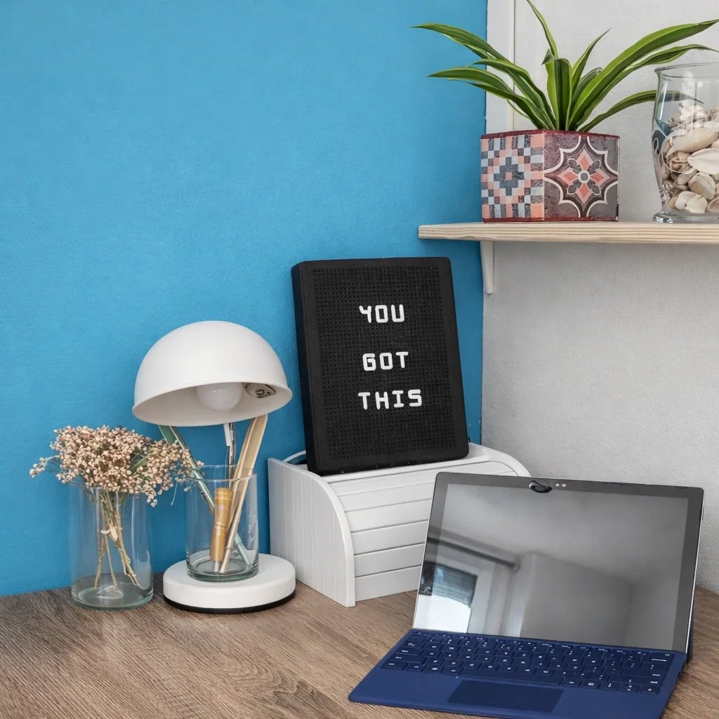 Compacte werkplek in de garage met blauwe accentwand, bureau en rustige accessoires – slim ingericht als multifunctionele man-cave met interieuradvies en styling door En-Casa Interiors in Heemskerk.