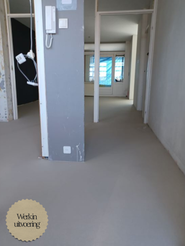 Procesfoto verbouwing: ingang en keuken in de ruwe fase. Stucwerk, installaties en nieuwe doorgangen leggen de basis voor het eindresultaat.