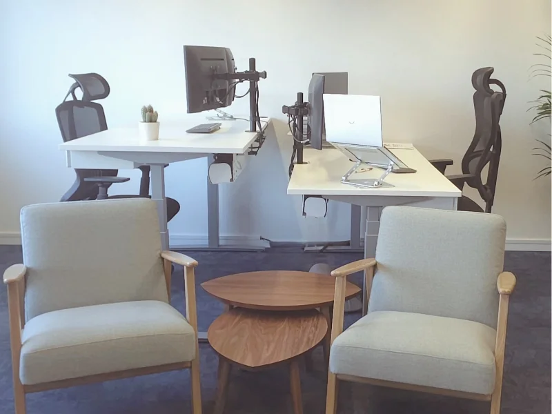 Herinrichting kantoorruimte: flexibele werkplekken met zit-sta bureaus, schermopstellingen en een comfortabele zithoek voor informele meetings. Interieuradvies, ontwerp en styling door En-Casa Interiors.