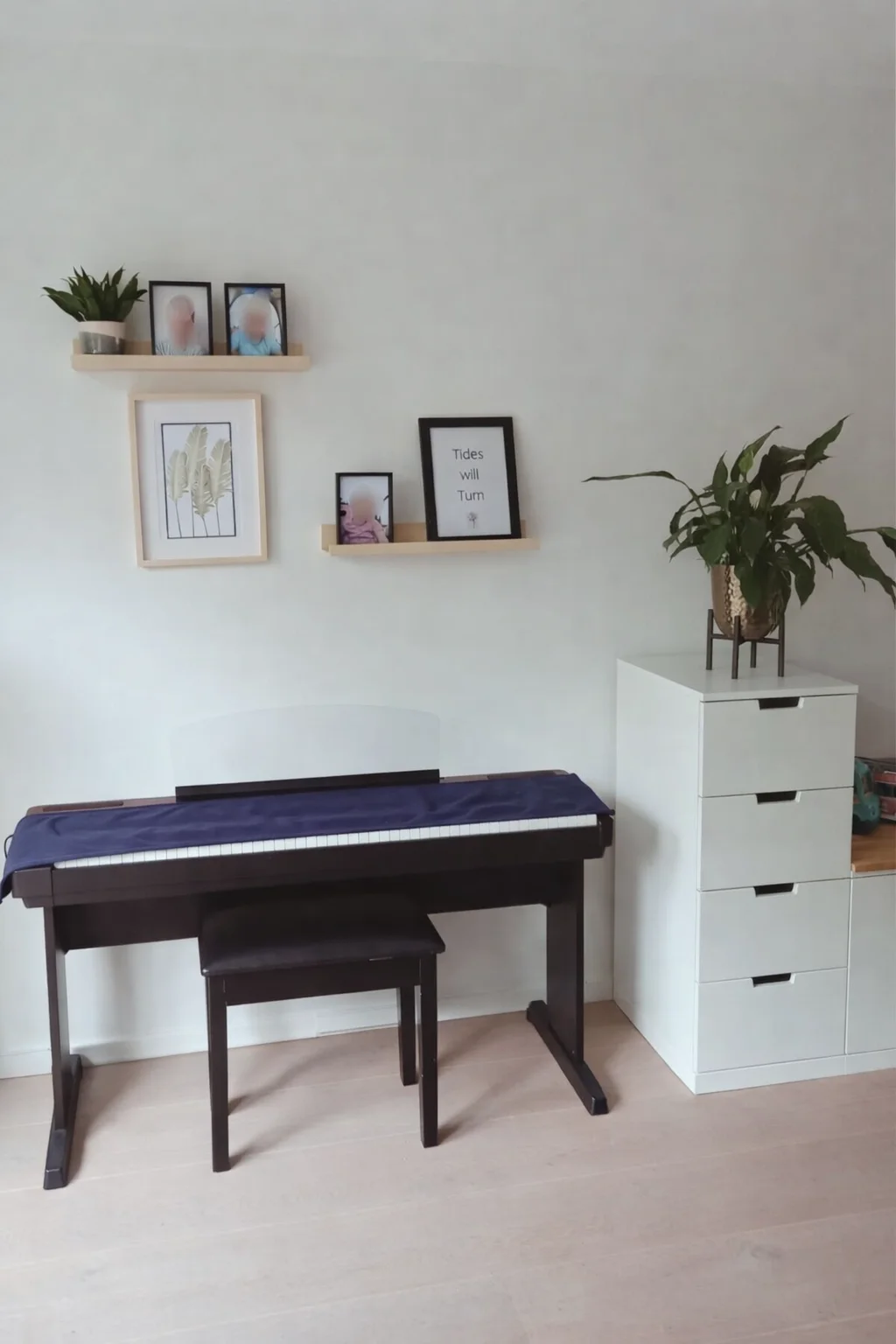 Rustige muziekhoek met digitale piano, minimalistische wandplanken en persoonlijke prints. Licht, overzichtelijk en warm gestyled met natuurlijke accenten — een fijne plek in huis om te spelen en te ontspannen, helemaal en casa.  Interieuradvies, int