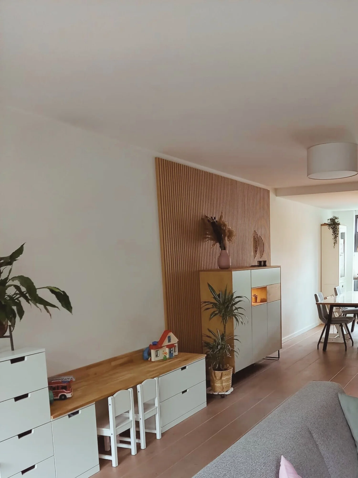 Lichte leefruimte met warm houten wandpaneel als blikvanger, rustige basis en een compacte werkplek aan de wand. Natuurlijke materialen en zachte kleuren zorgen voor sfeer en een duidelijke indeling — een en casa dat praktisch én gezellig voelt.  Int