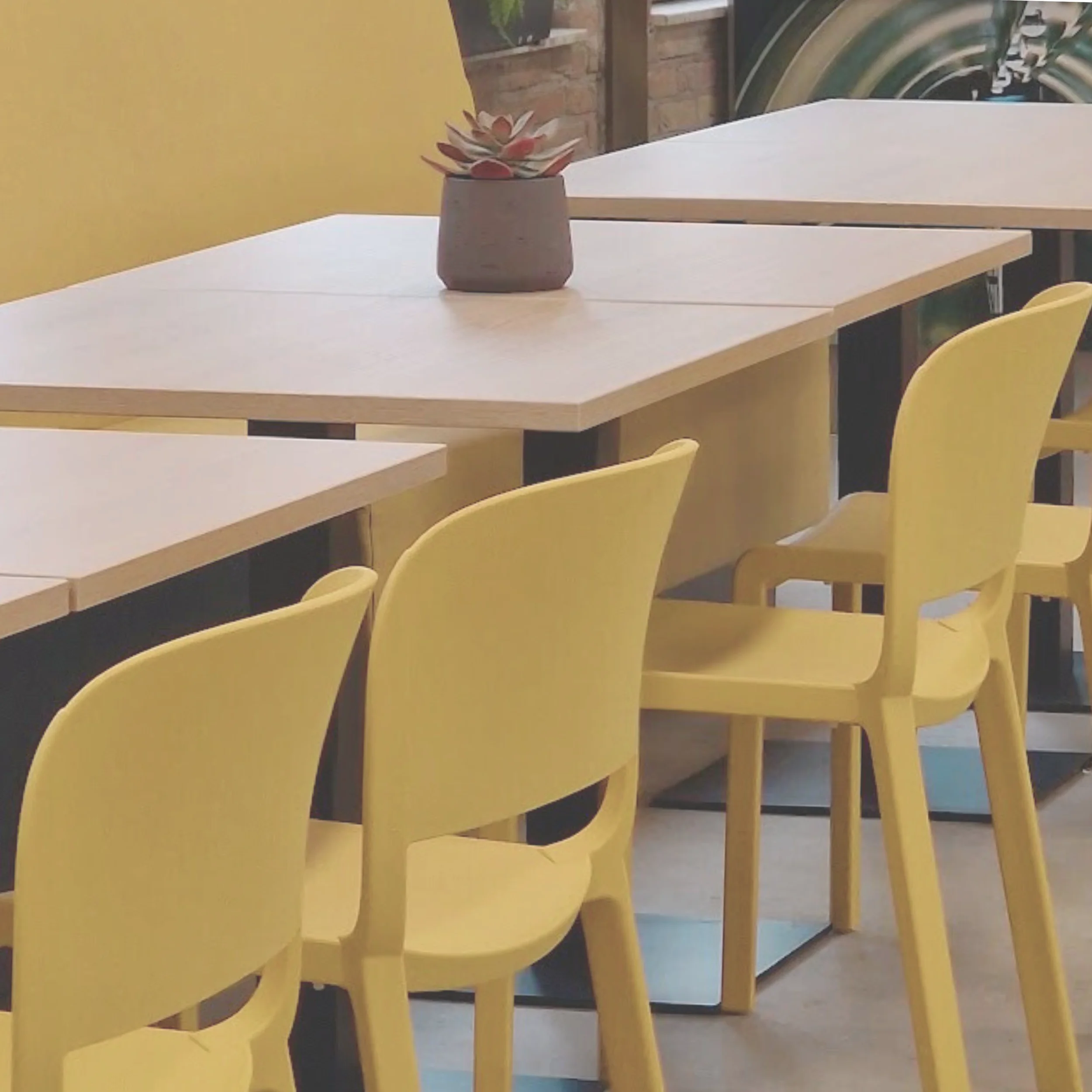 Interieurontwerp voor bedrijfskantine met okergele stoelen en lichte tafels in moderne lunchruimte – zakelijk interieuradvies En-Casa Interiors, Noord-Holland.