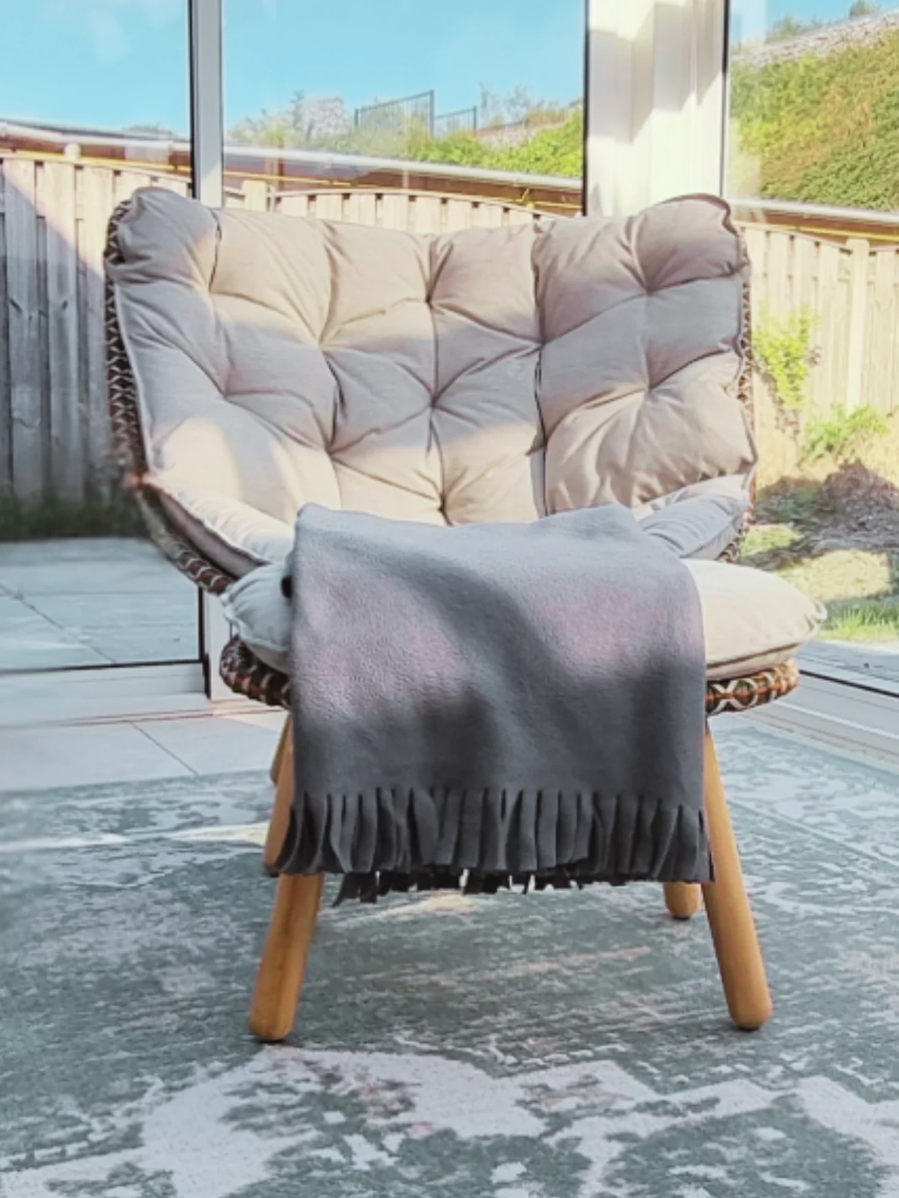Gezellige zithoek in de veranda met warme natuurtinten, comfortabele zitplaatsen en sfeervolle accessoires die rust en balans creëren. Interieuradvies, interieurontwerp en styling door En-Casa Interiors in Noord-Holland.