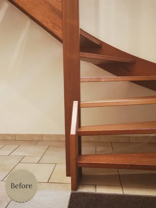 Oude situatie: open houten trap zonder trapkast, met zicht op de lege ruimte onder de trap in de entree, in Heemskerk.
