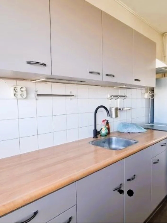 Foto’s before van de keuken: klassieke kastfronten, tegelwand en houtlook werkblad. Ideale basis om te vernieuwen met een strak plan.