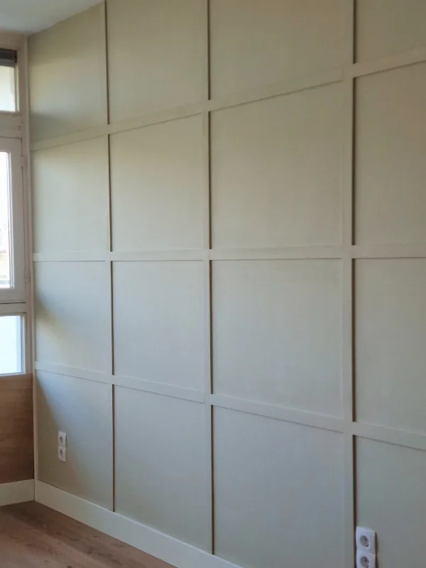 Strakke wandafwerking met maatwerk panelen en sierlijsten in een zachte, neutrale tint – geeft de ruimte direct meer diepte, ritme en een luxe, rustige uitstraling.