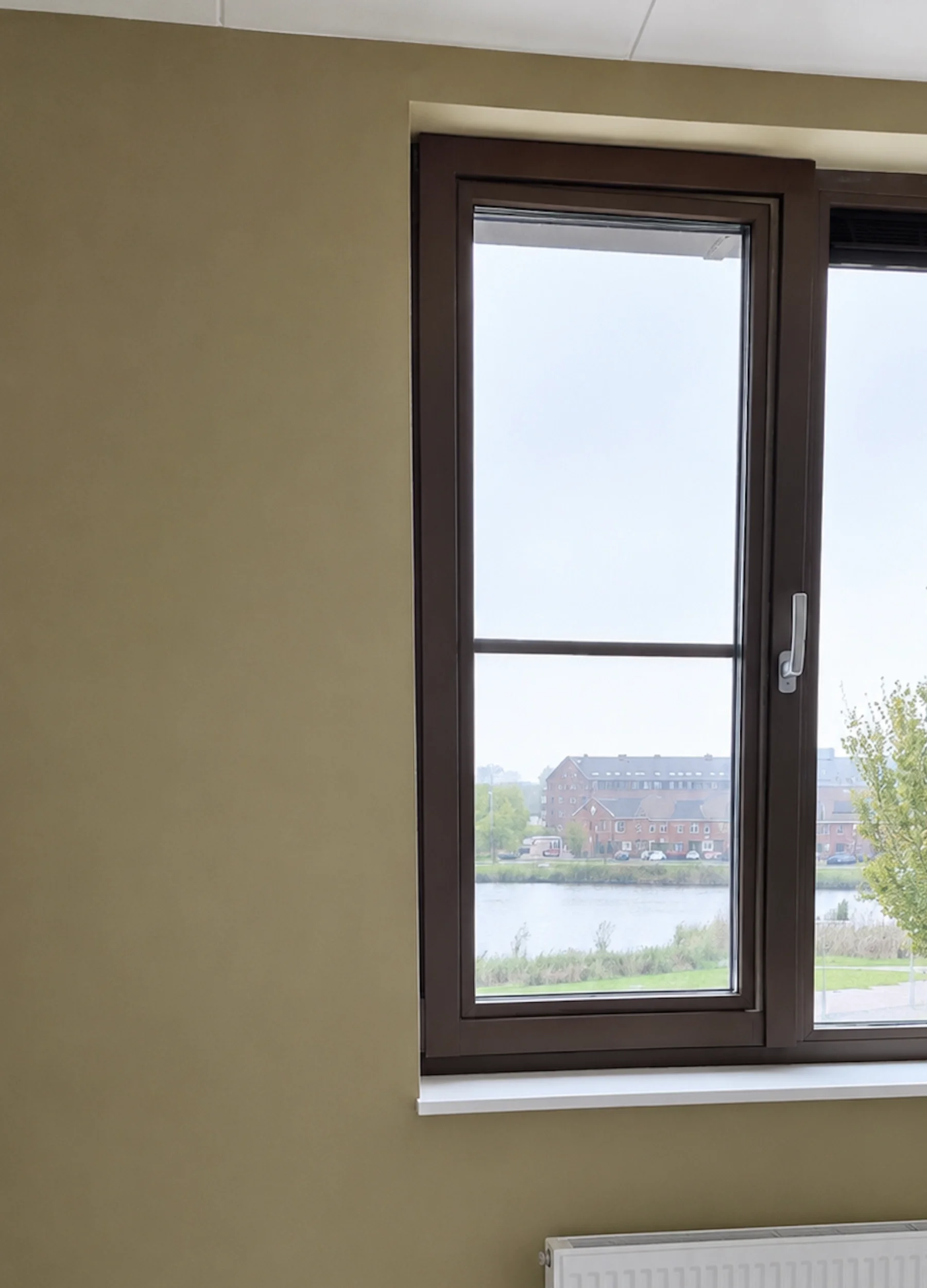 Warme groentint op de wand van een werkkamer in Heemskerk, afgestemd op het bestaande interieur en kleurenpalet.