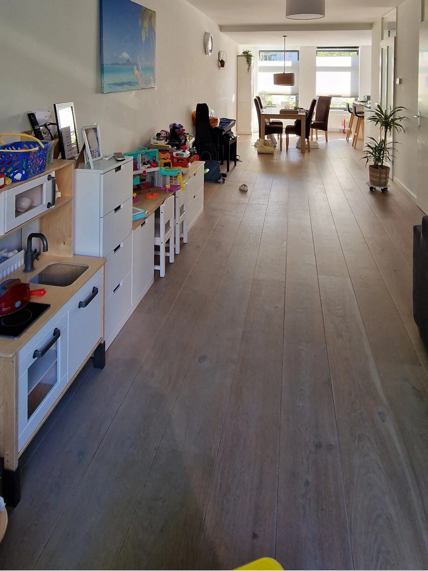 Voor situatie van de woon- en eetkamer met een lange wand, open indeling, lichte basis en een speelhoek voor de kinderen als uitgangspunt voor een nieuw interieuradvies in Aalsmeer.