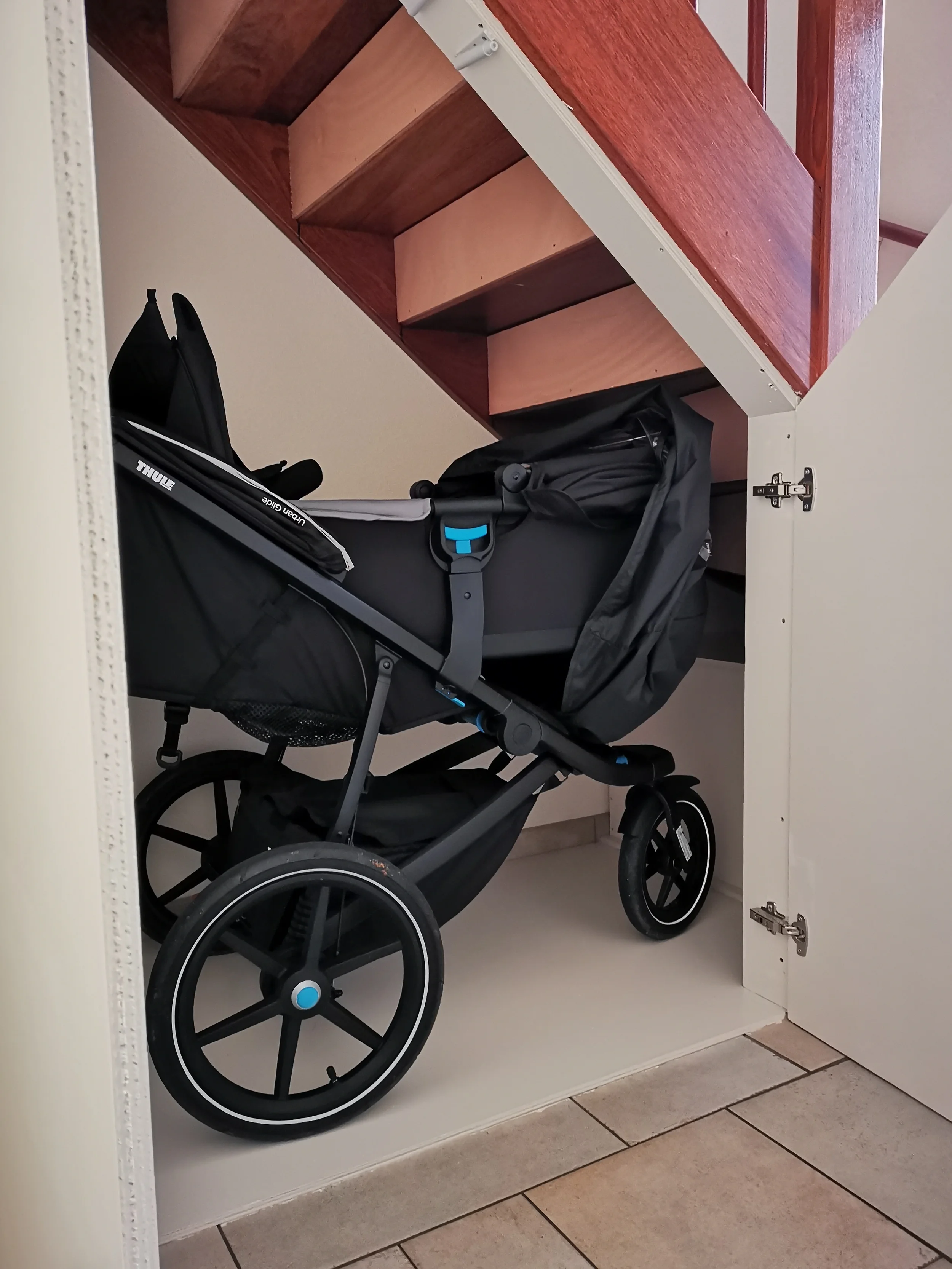 Maatwerk trapkast met ruime opbergruimte voor een kinderwagen onder de trap, ontworpen voor een praktische en rustige entree in Heemskerk.