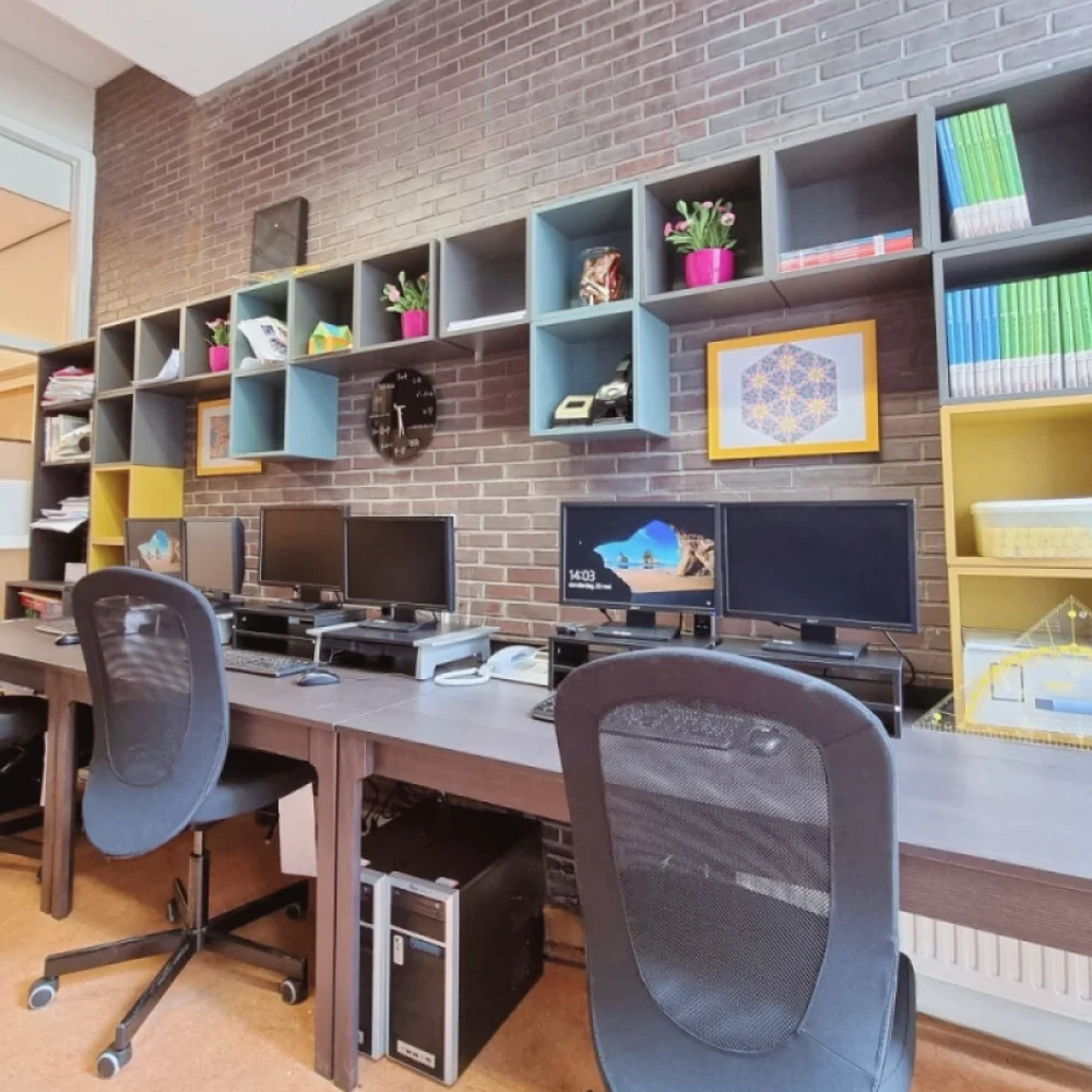 Industriële kantoorinrichting met drie werkplekken, maatwerk kastenwand, bakstenen muur en veel daglicht voor een efficiënte en overzichtelijke werkruimte. Interieuradvies, ontwerp en styling door En-Casa Interiors.