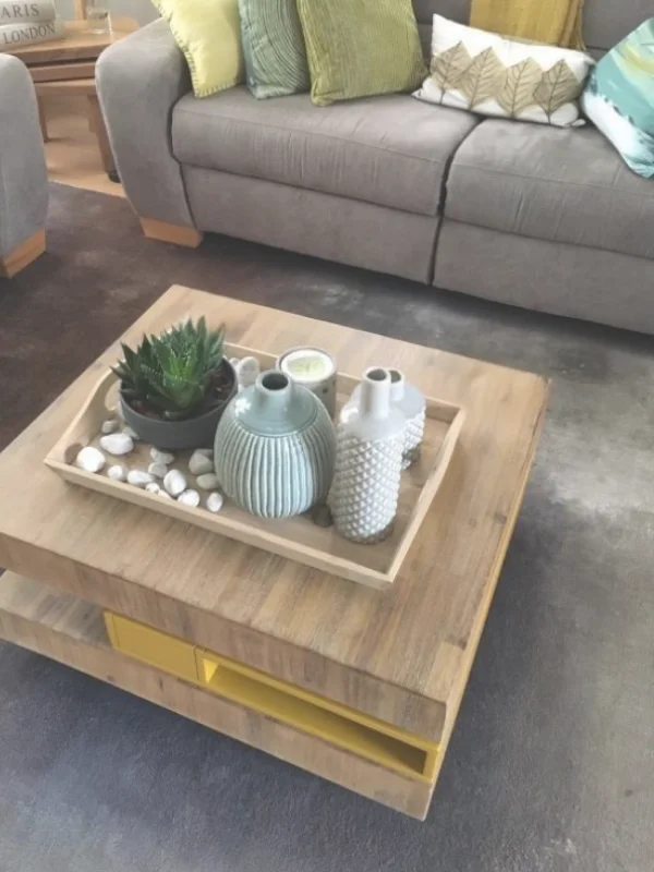 Deze foto toont de vernieuwde zithoek uit het project woonkamer & eetkamer make-over. Een rustige, warme basis met een taupe bank en natuurlijke tinten zorgt voor balans en comfort. Groene en okergele kussens brengen een fris kleuraccent, terwijl het