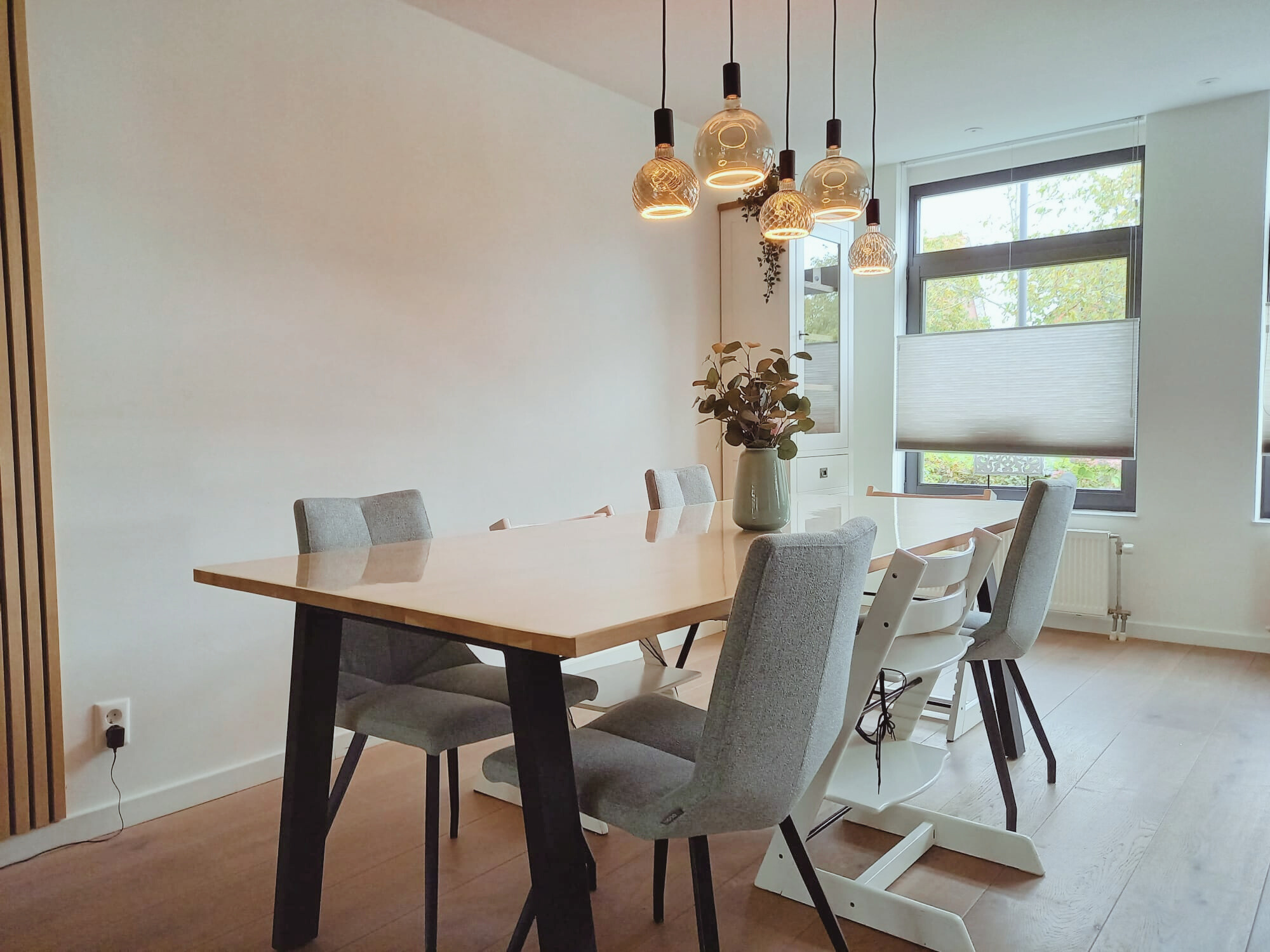 Stijlvolle wand met houten lattenpaneel en strak dressoir in zachte groentint, met warm verlichte nis voor decoratie. Een moderne, rustige basis met natuurlijke materialen en een speels detail — voor een en casa dat klopt in sfeer en functionaliteit.