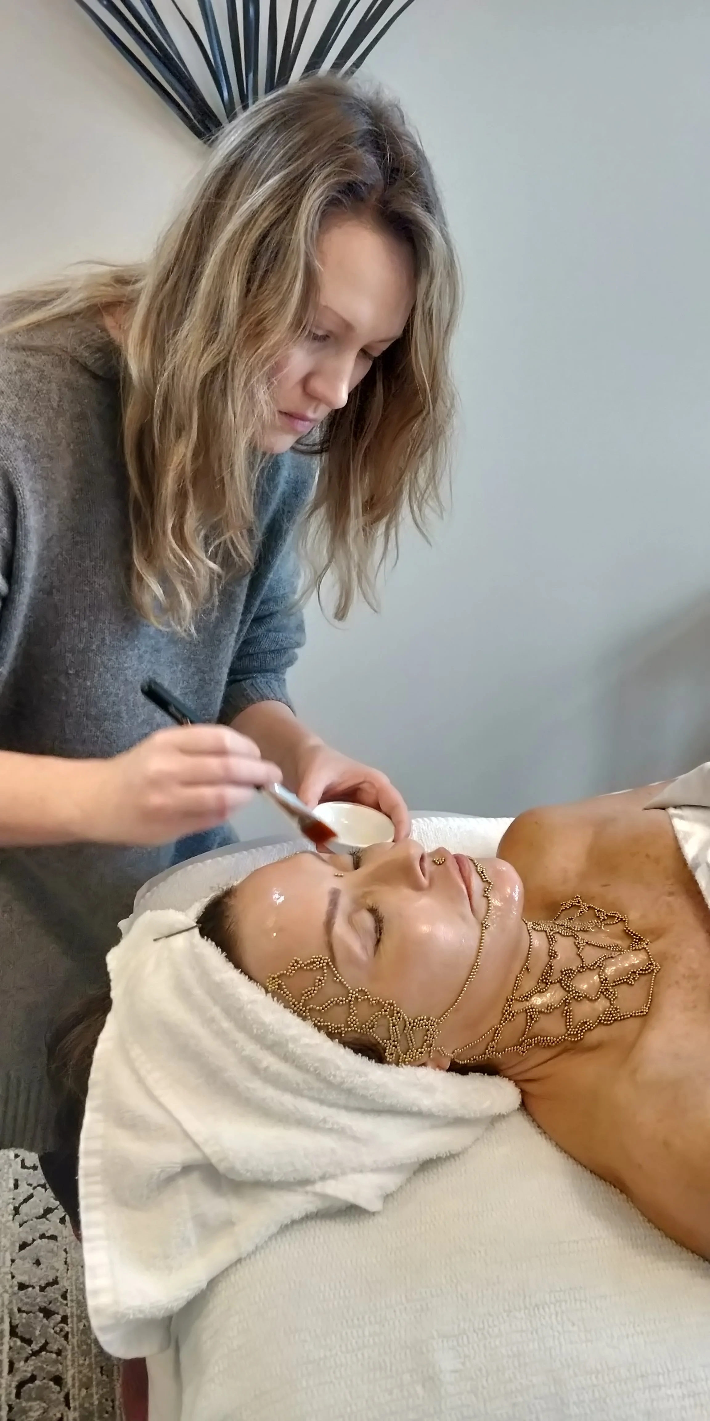Qi beauty Training with Lisa Dallin, Practitioner completing a Neck, face treatment
