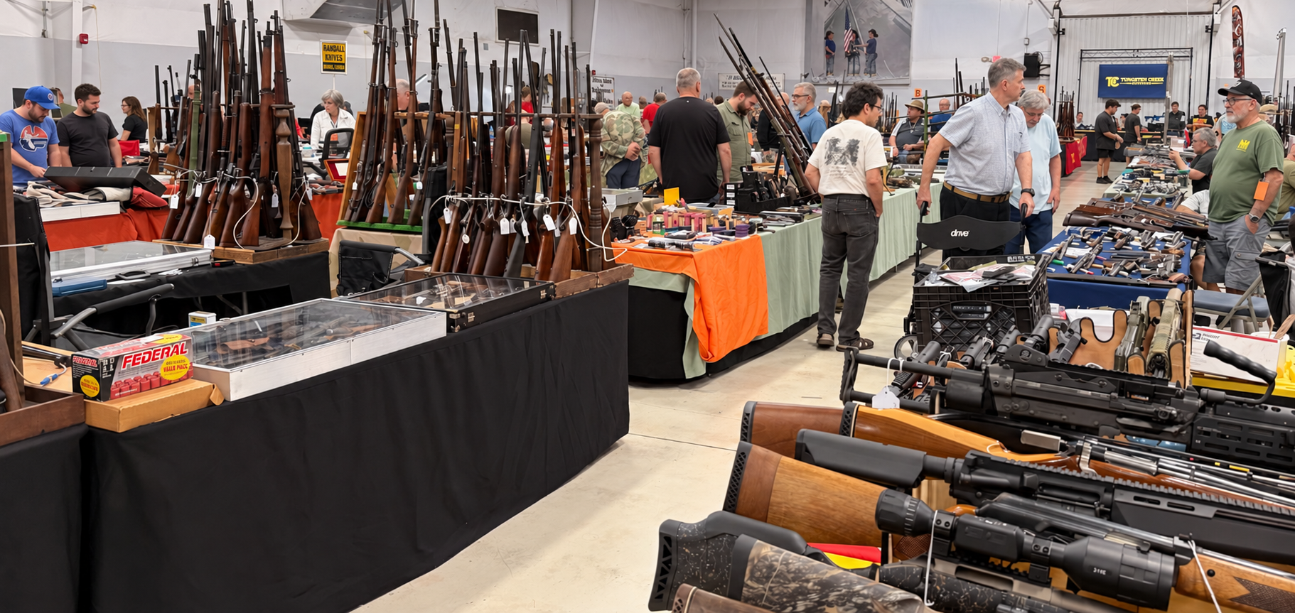 Gun show floor with variety of displays and people browsing