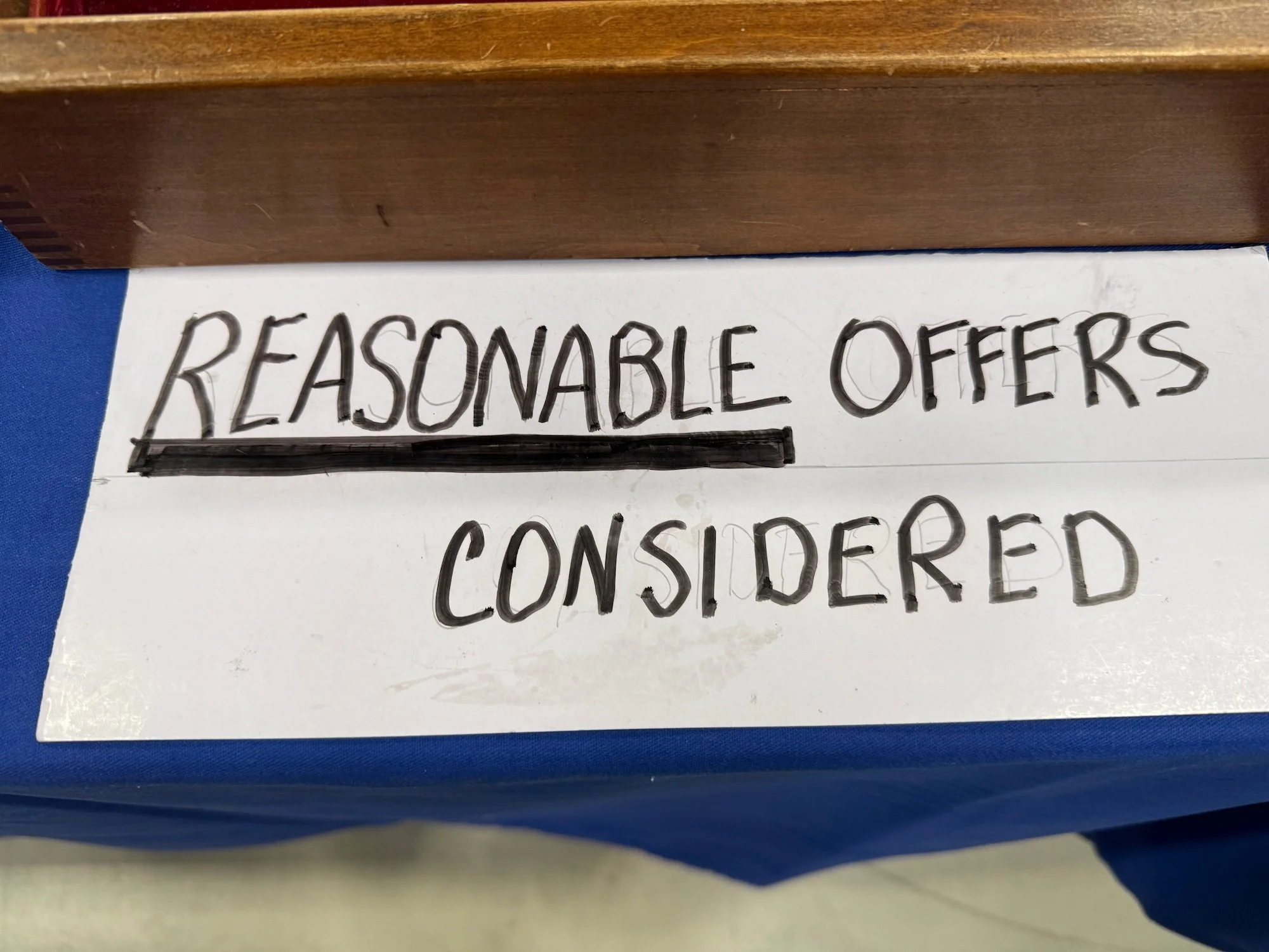 Sign with handwritten text: 'Reasonable offers considered' with the word 'Reasonable' underlined.