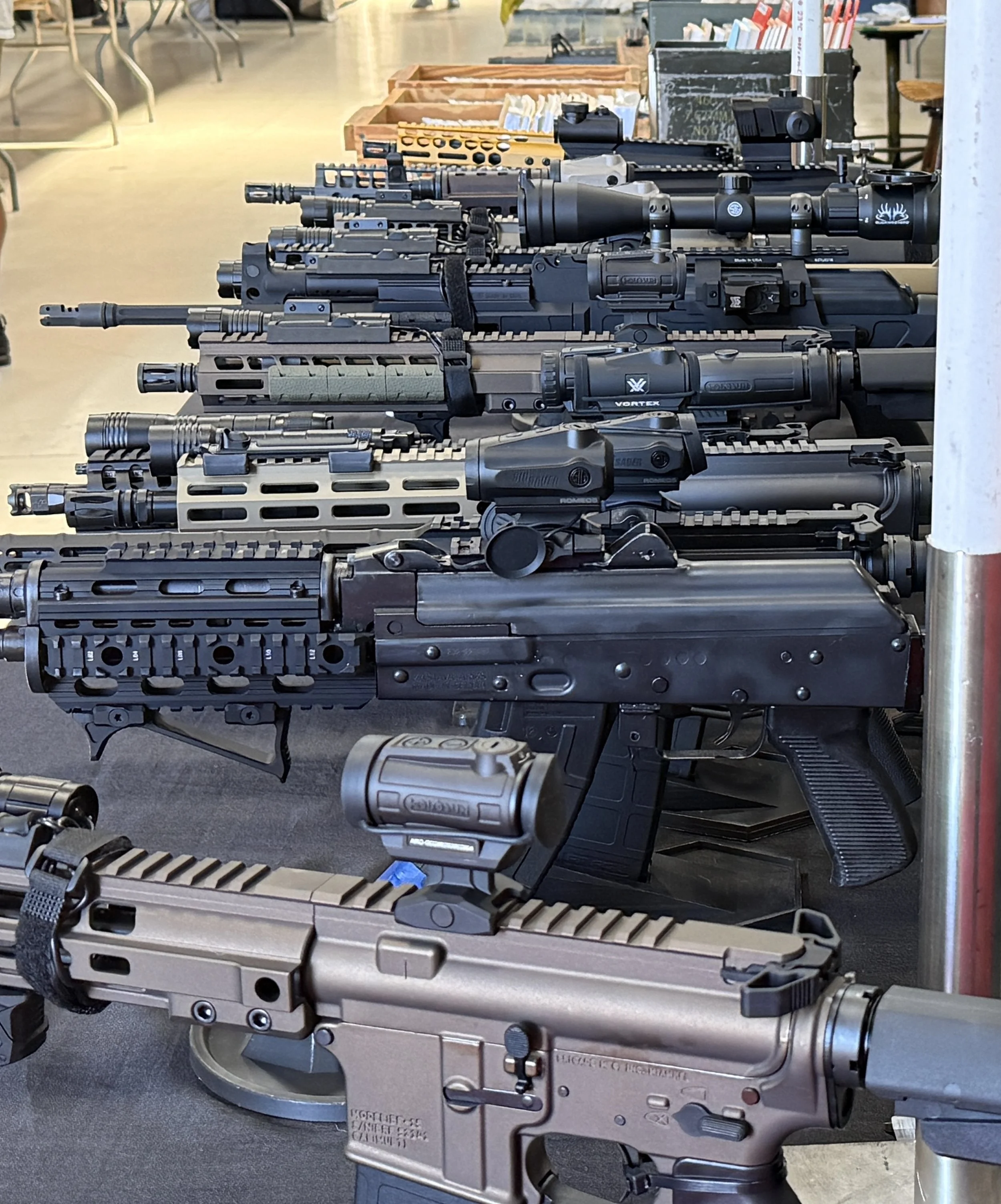 Gun show display of modern rifles
